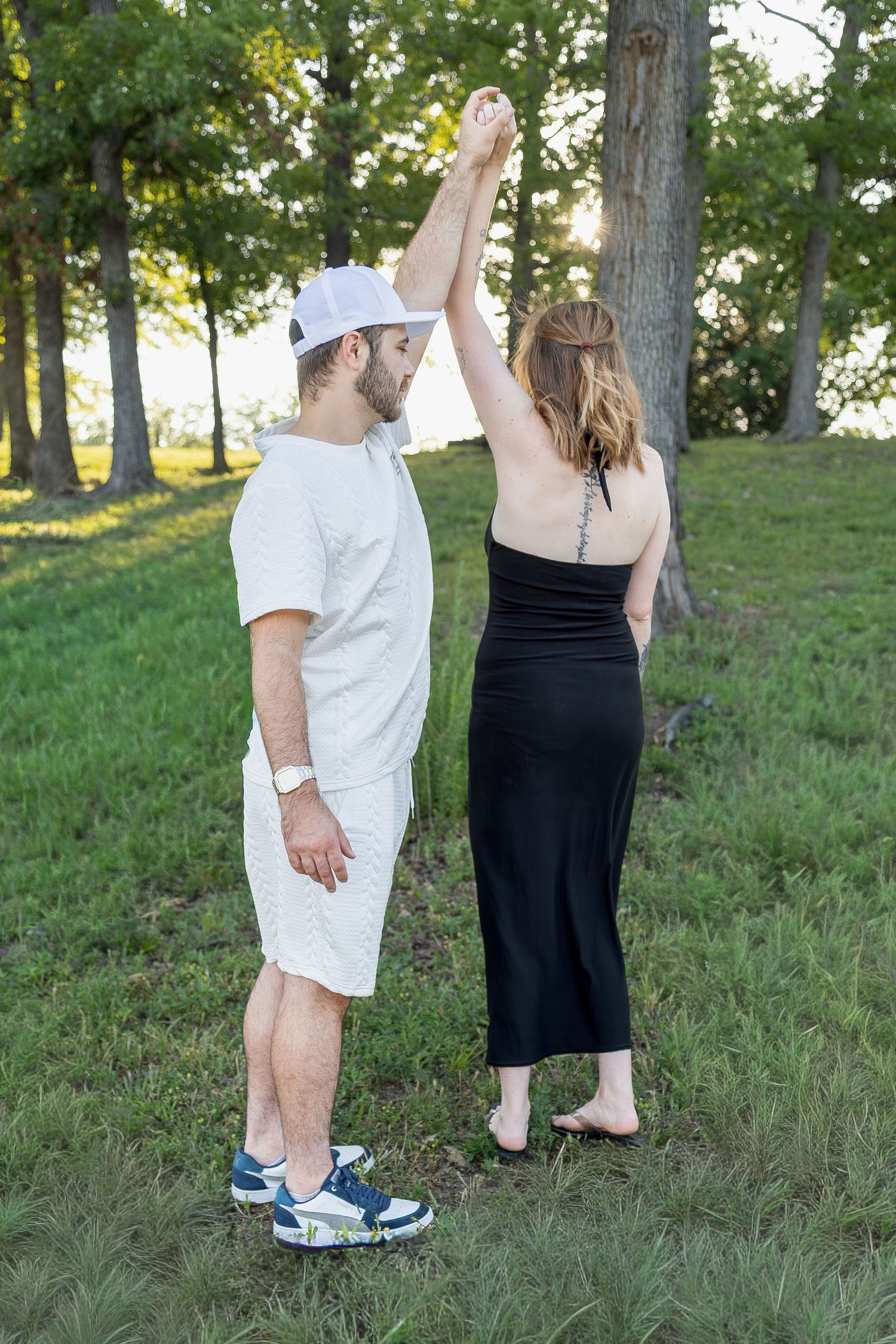 Engaged couple sharing romantic moments during an outdoor engagement session with natural posing, genuine smiles, and golden-hour light.