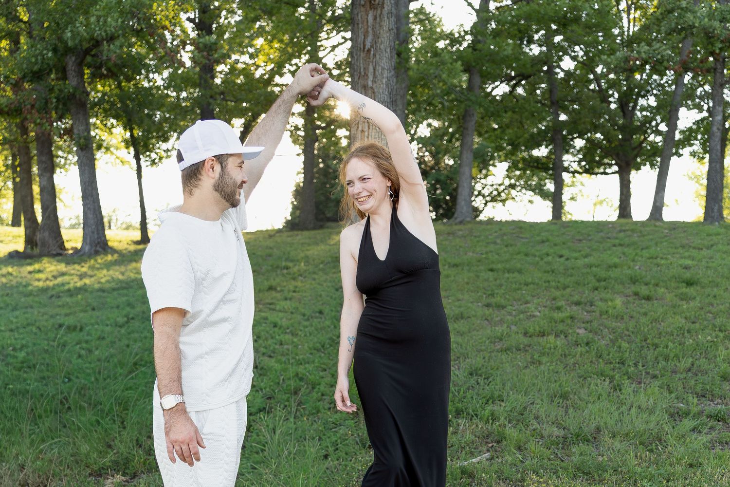 Engaged couple sharing romantic moments during an outdoor engagement session with natural posing, genuine smiles, and golden-hour light.