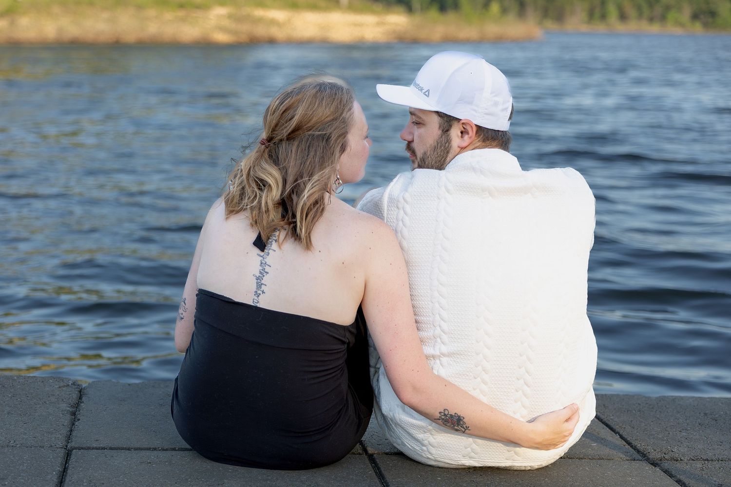 Engaged couple sharing romantic moments during an outdoor engagement session with natural posing, genuine smiles, and golden-hour light.