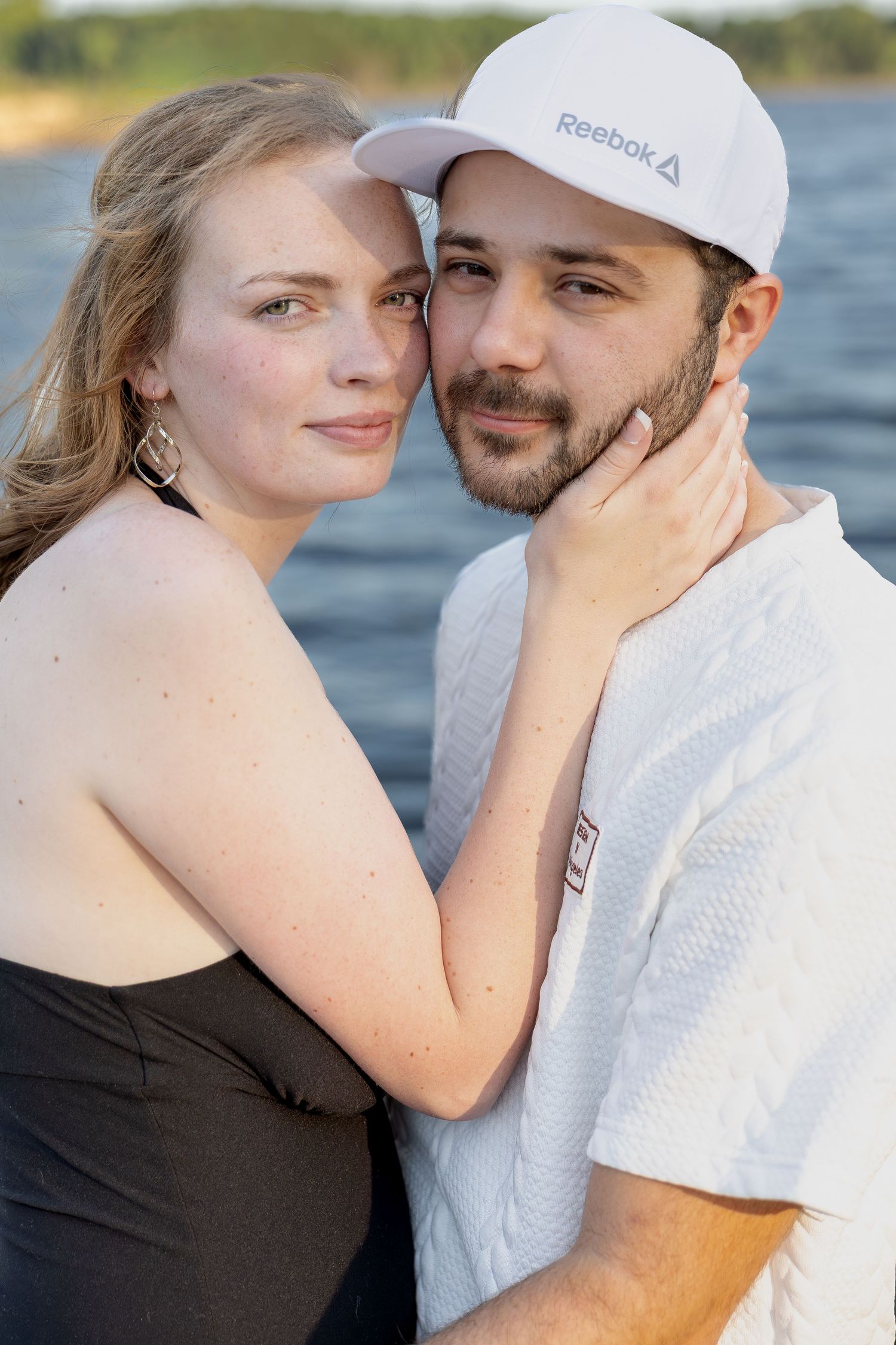 Engaged couple sharing romantic moments during an outdoor engagement session with natural posing, genuine smiles, and golden-hour light.