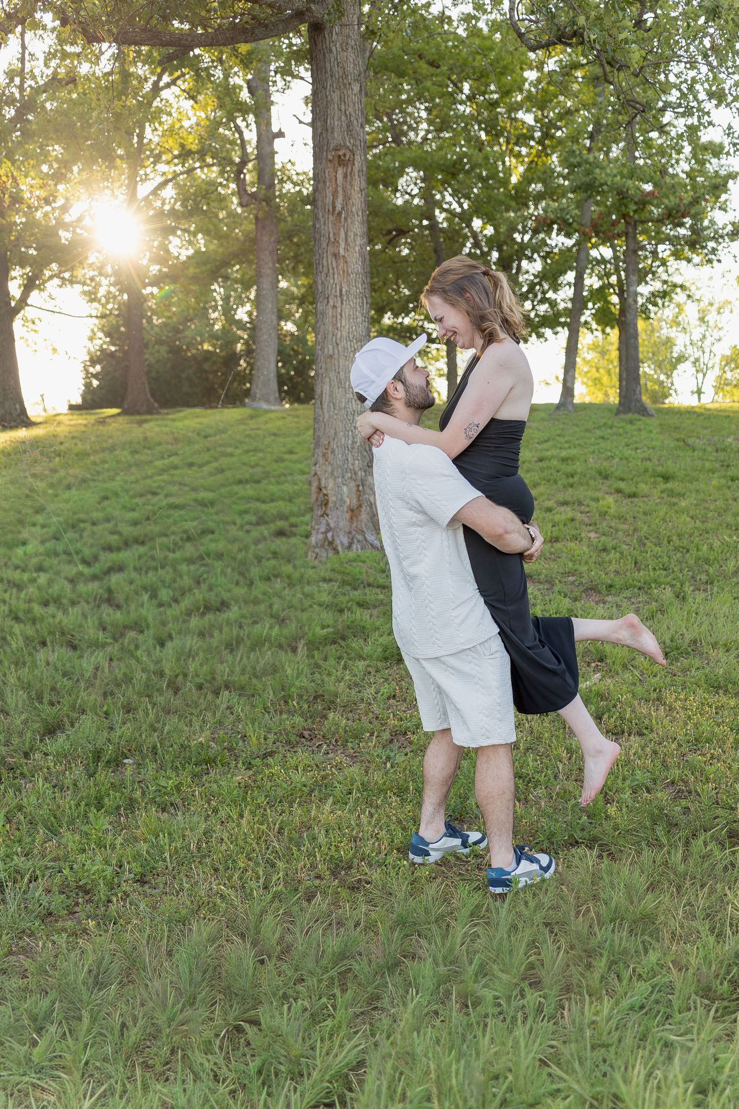 Engaged couple sharing romantic moments during an outdoor engagement session with natural posing, genuine smiles, and golden-hour light.