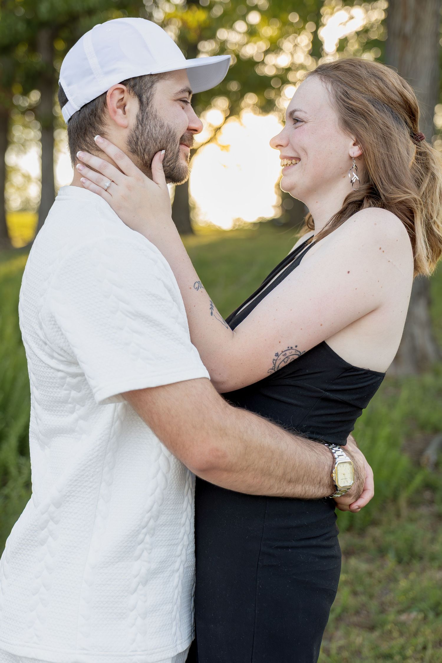 Engaged couple sharing romantic moments during an outdoor engagement session with natural posing, genuine smiles, and golden-hour light.