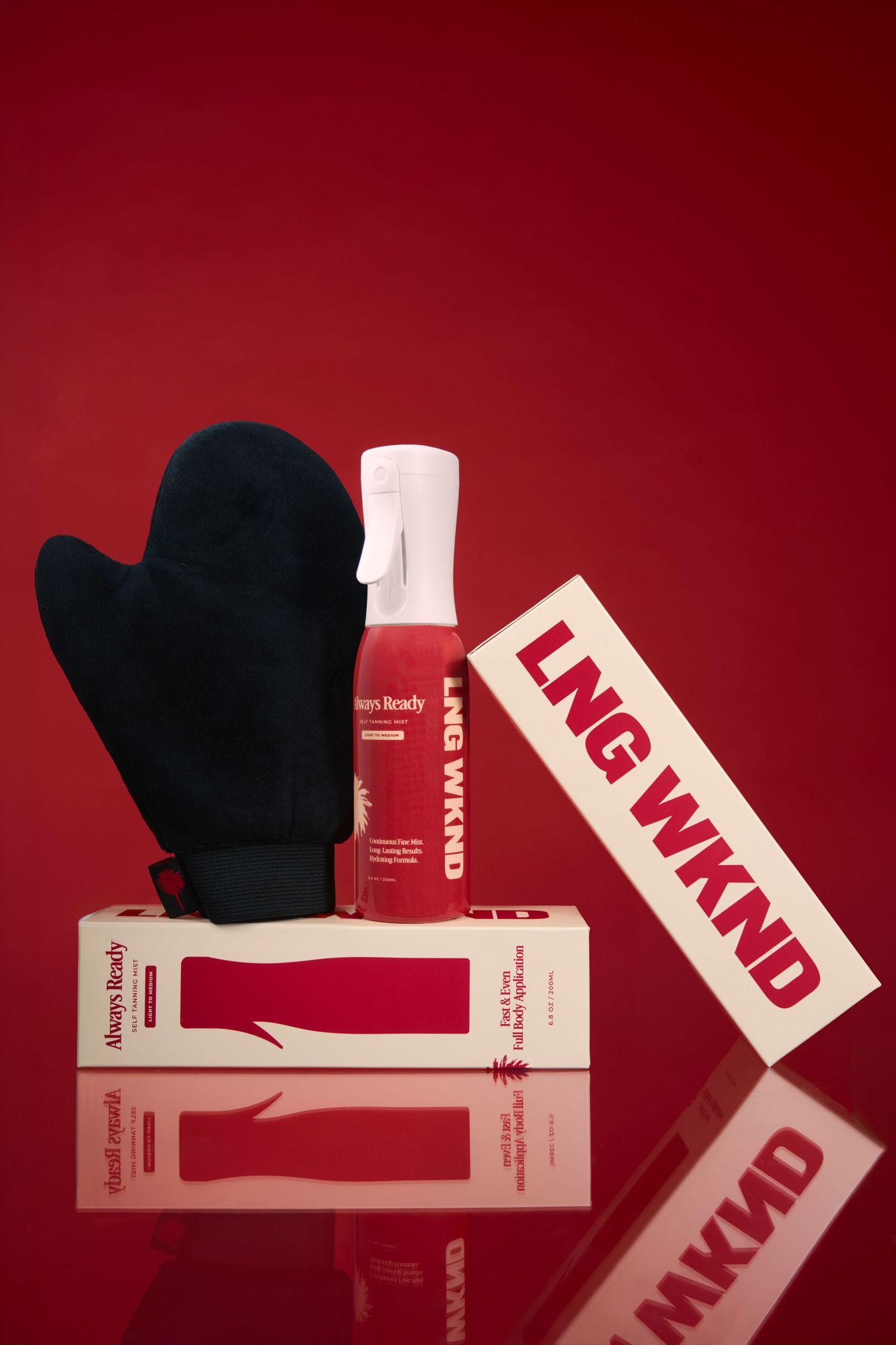 LNG WKND self-tan kit with red spray bottle, black tanning mitt, and branded box on red background.