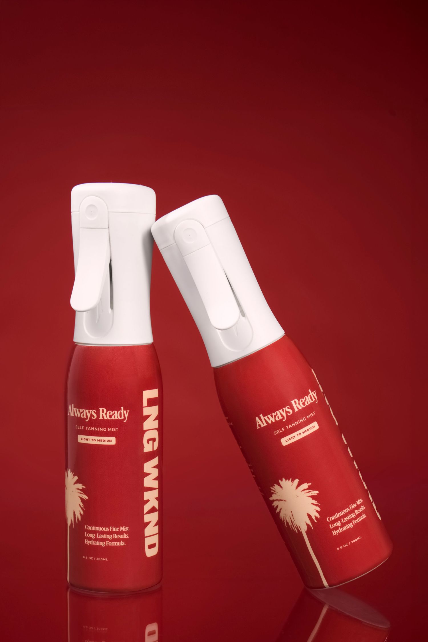 Two red spray bottles of Always Ready LNG WKND self-tanning mist displayed against a red background.