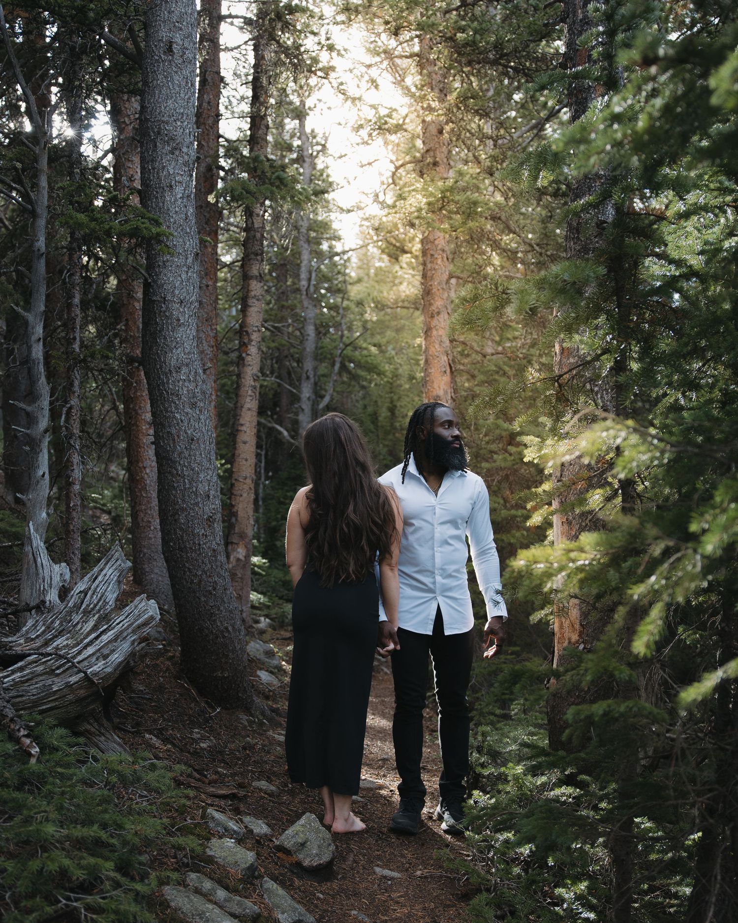 Couple embracing among pine trees during a Roosevelt National Forest photography session