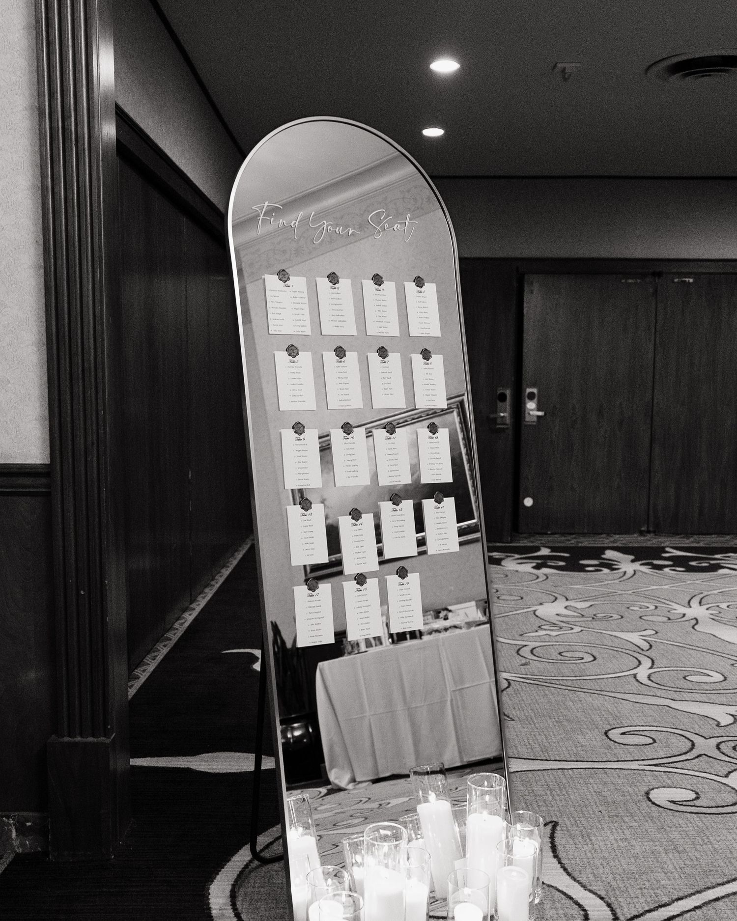 Black and white photo of snowboard seating chart display at elegant wedding reception.