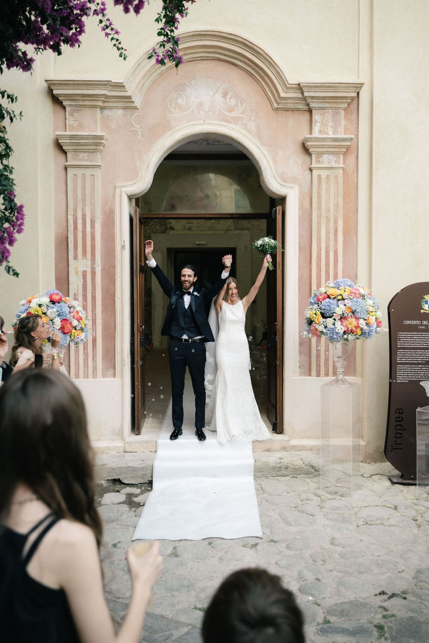 Giulia and Metz celebrating as they leave their wedding ceremony