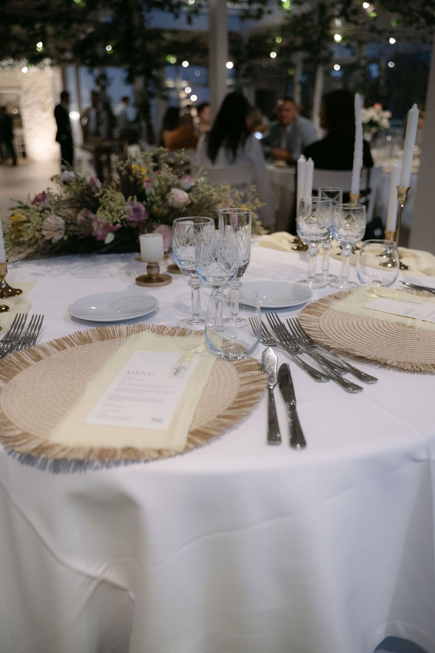 Wedding reception table with floral arrangements and elegant glassware
