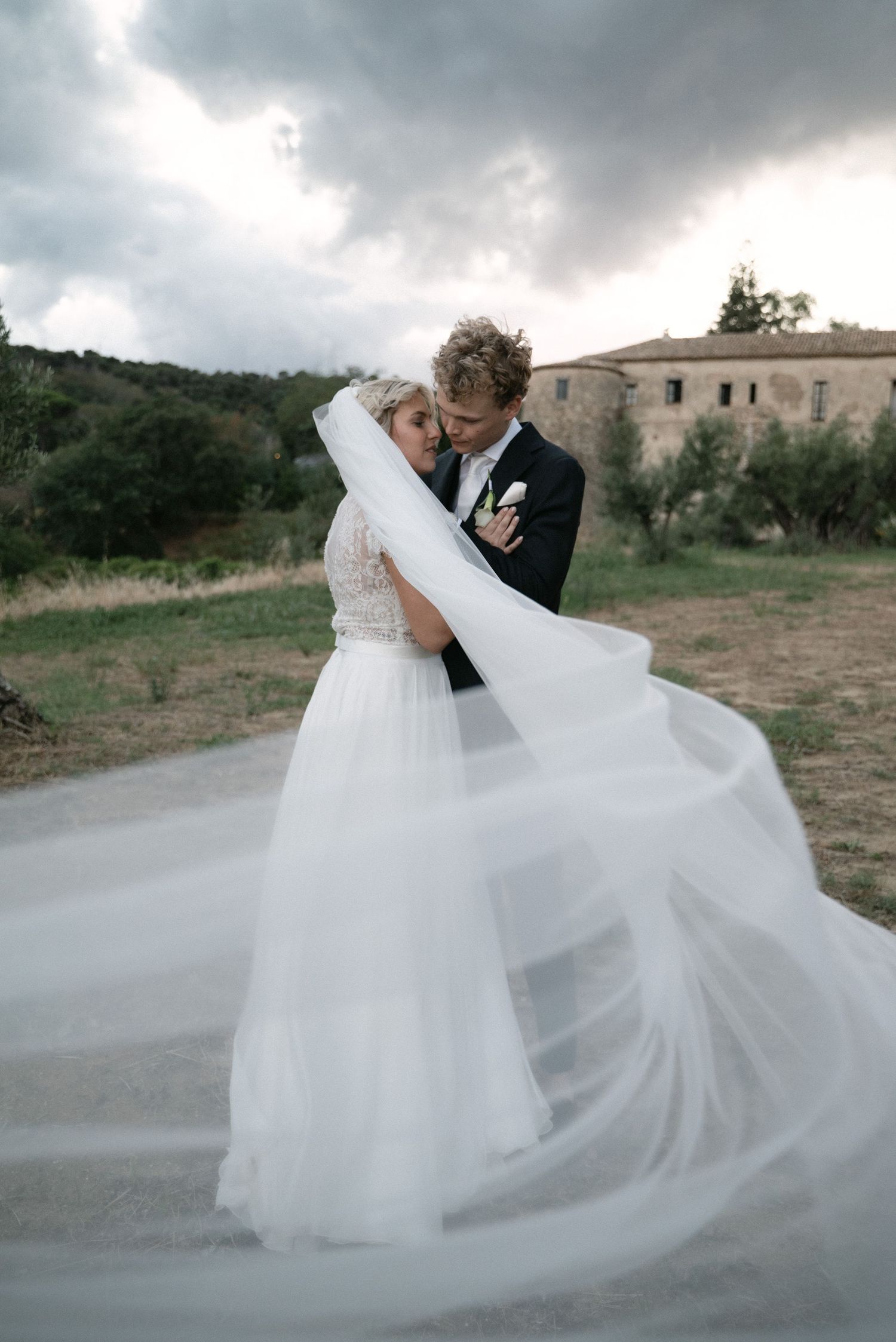 Serena and Paul embracing against the landscape of Southern Italy