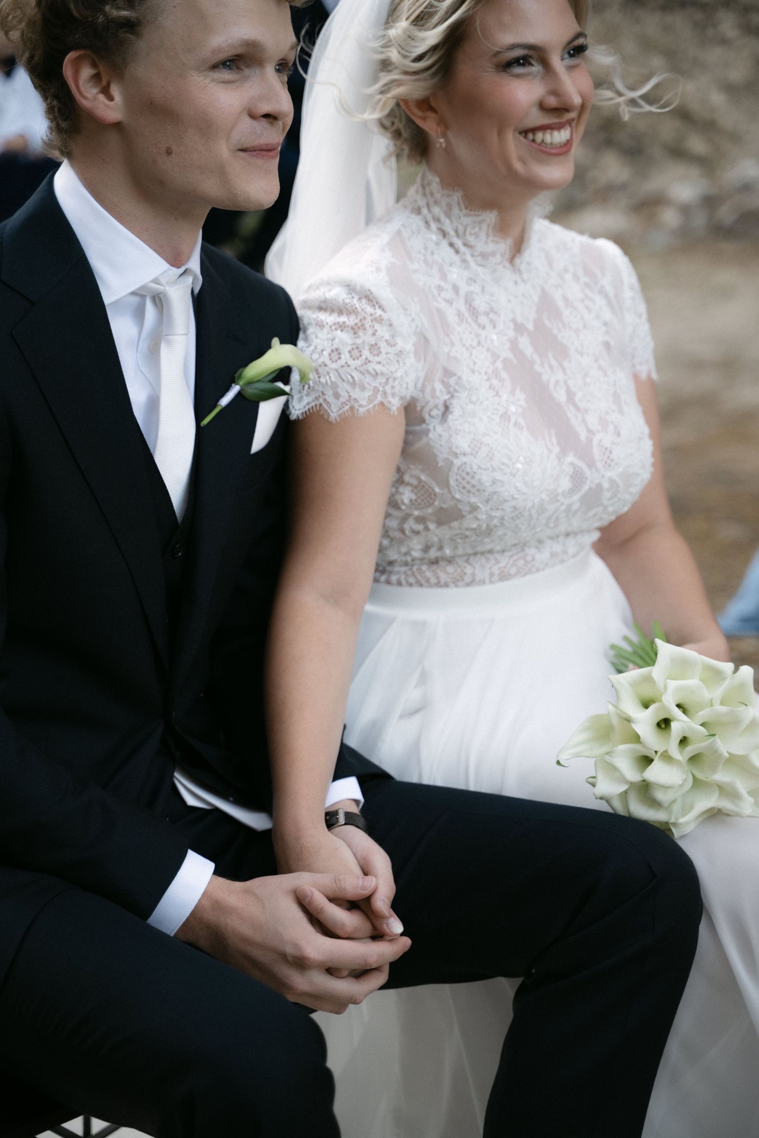 Close-up of the bride and groom holding hands