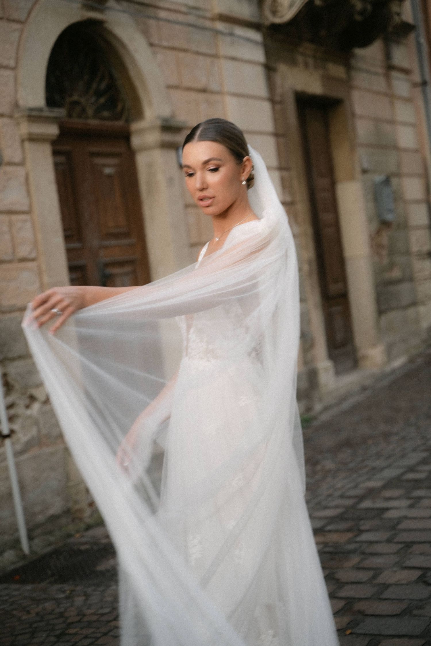 Bride moving her veil during wedding portraits in the historic streets