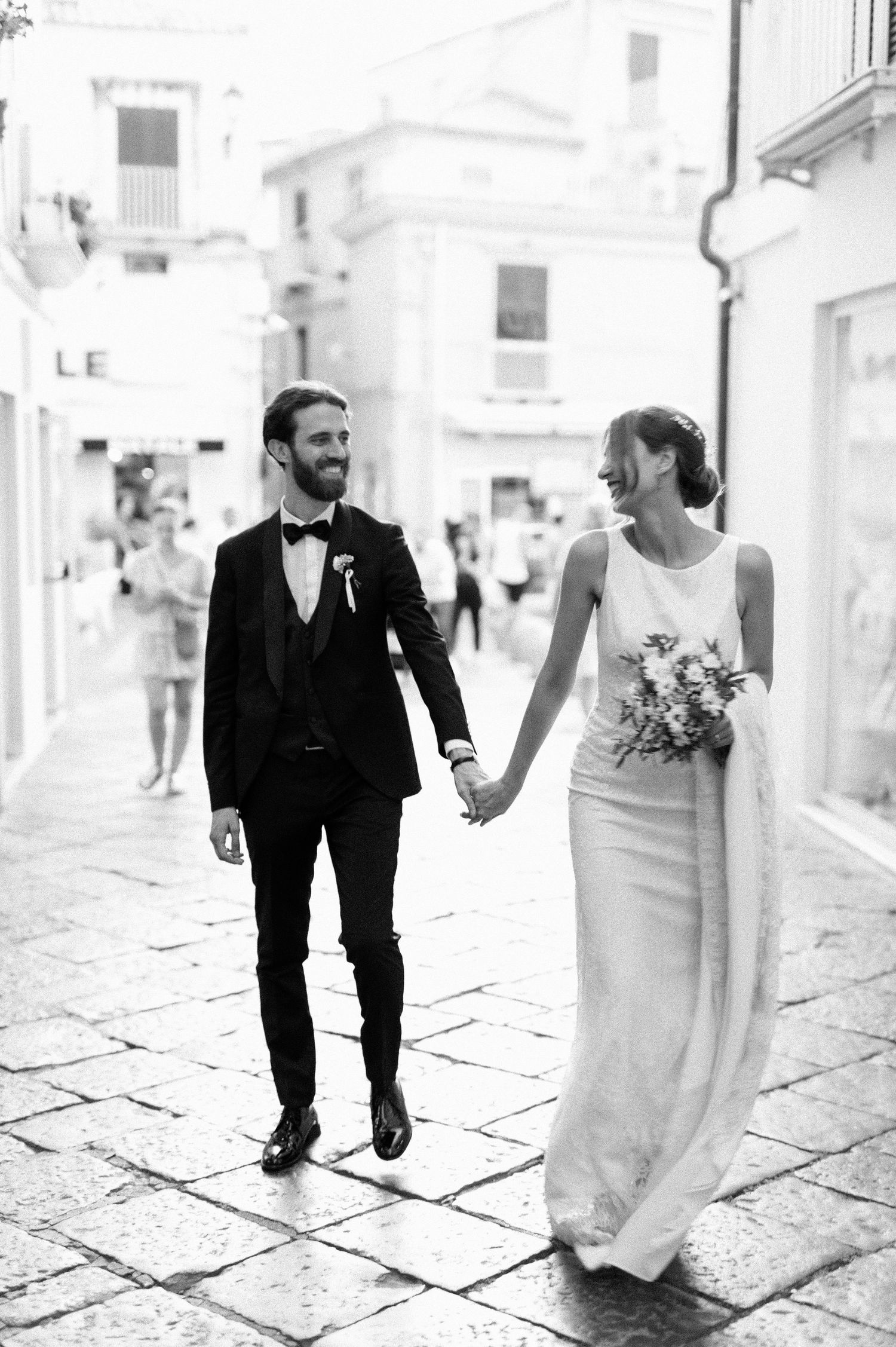 Bride and groom walking through Tropea in black and white