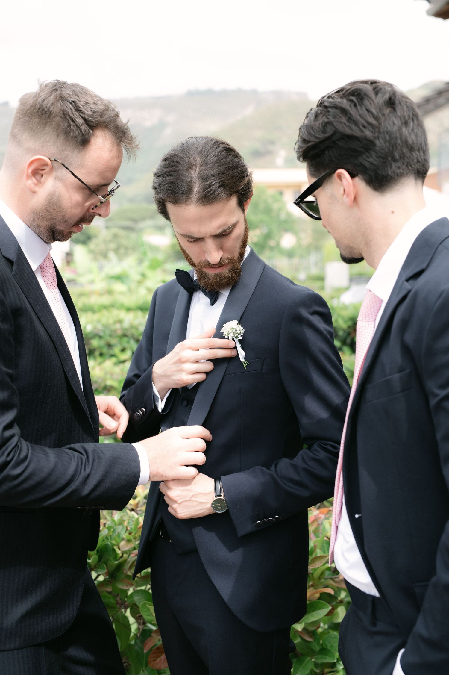 Groom and friends preparing the boutonniere before the wedding
