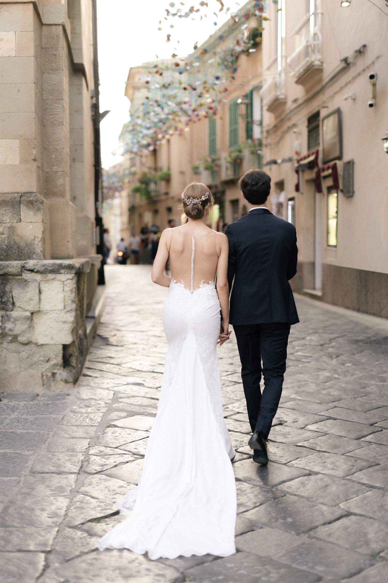Newlyweds walking together through the historic centre of Tropea