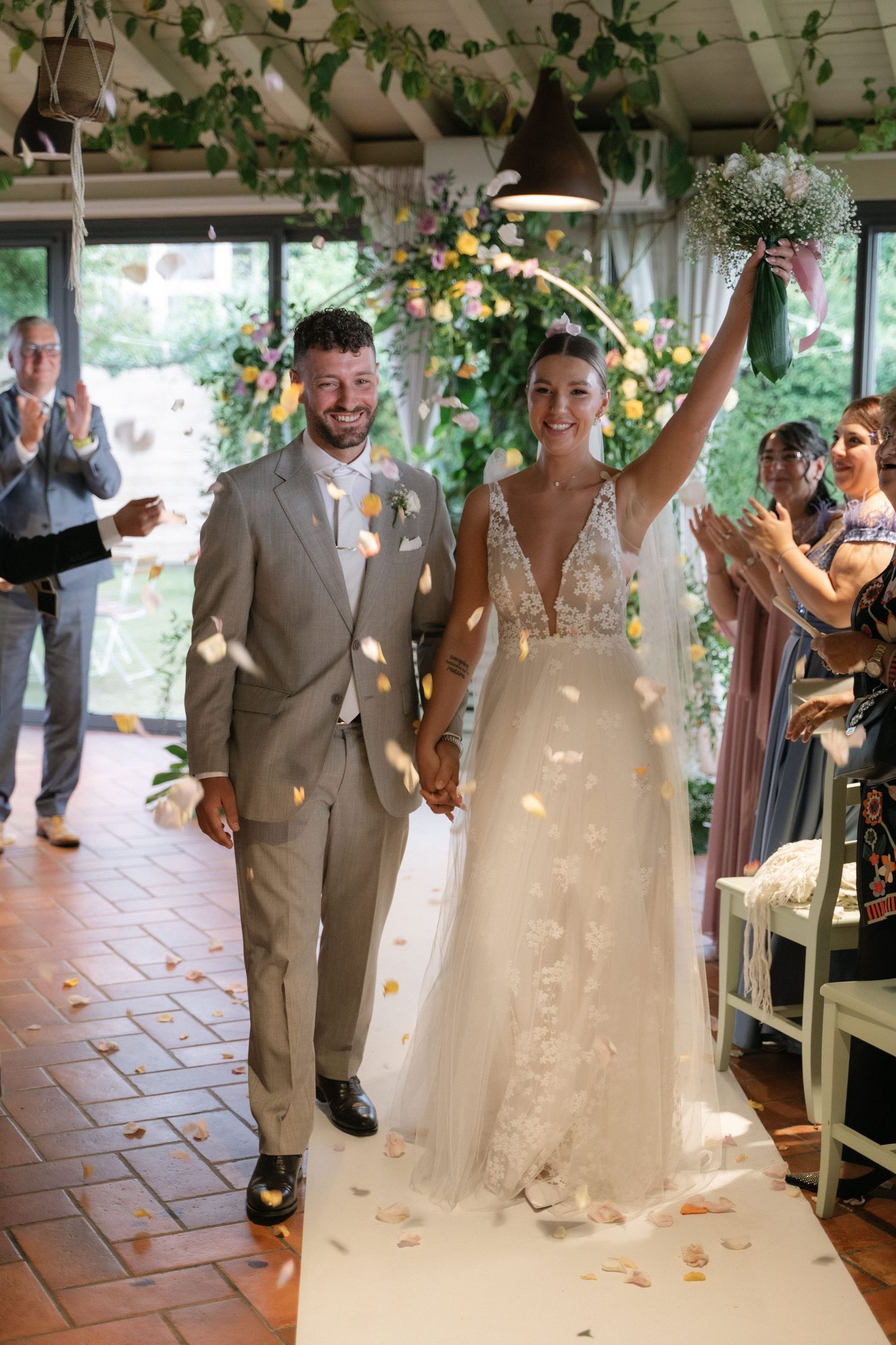 Newlyweds leaving their wedding ceremony through falling flower petals