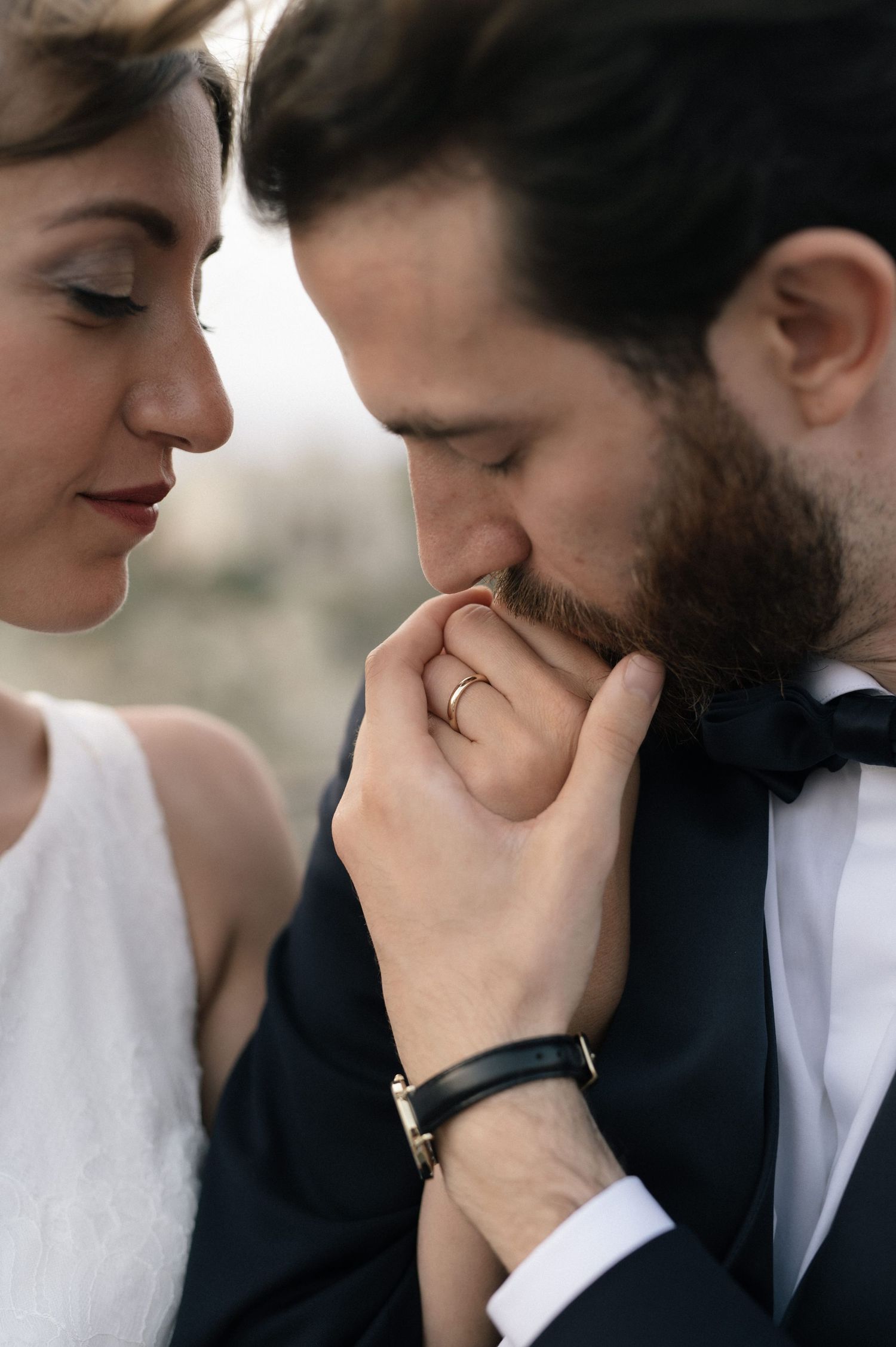 Groom kissing the bride's hand during their wedding portraits