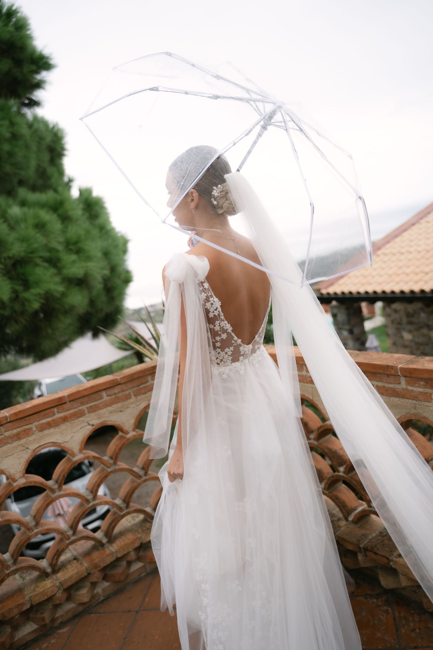 Bride walking beneath a transparent umbrella before her Sicily wedding