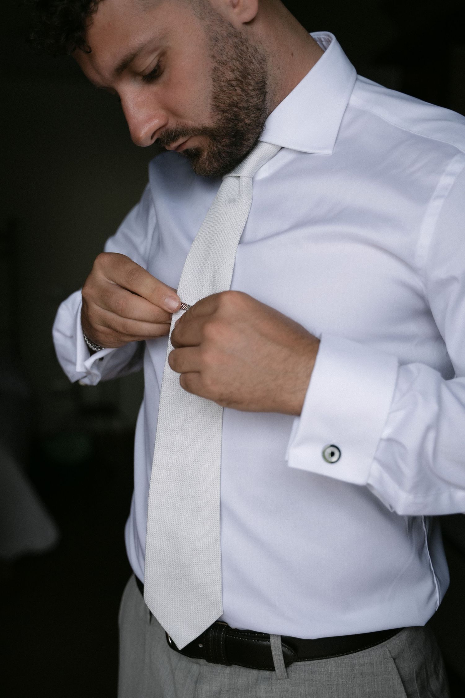 Groom adjusting his tie during wedding preparations