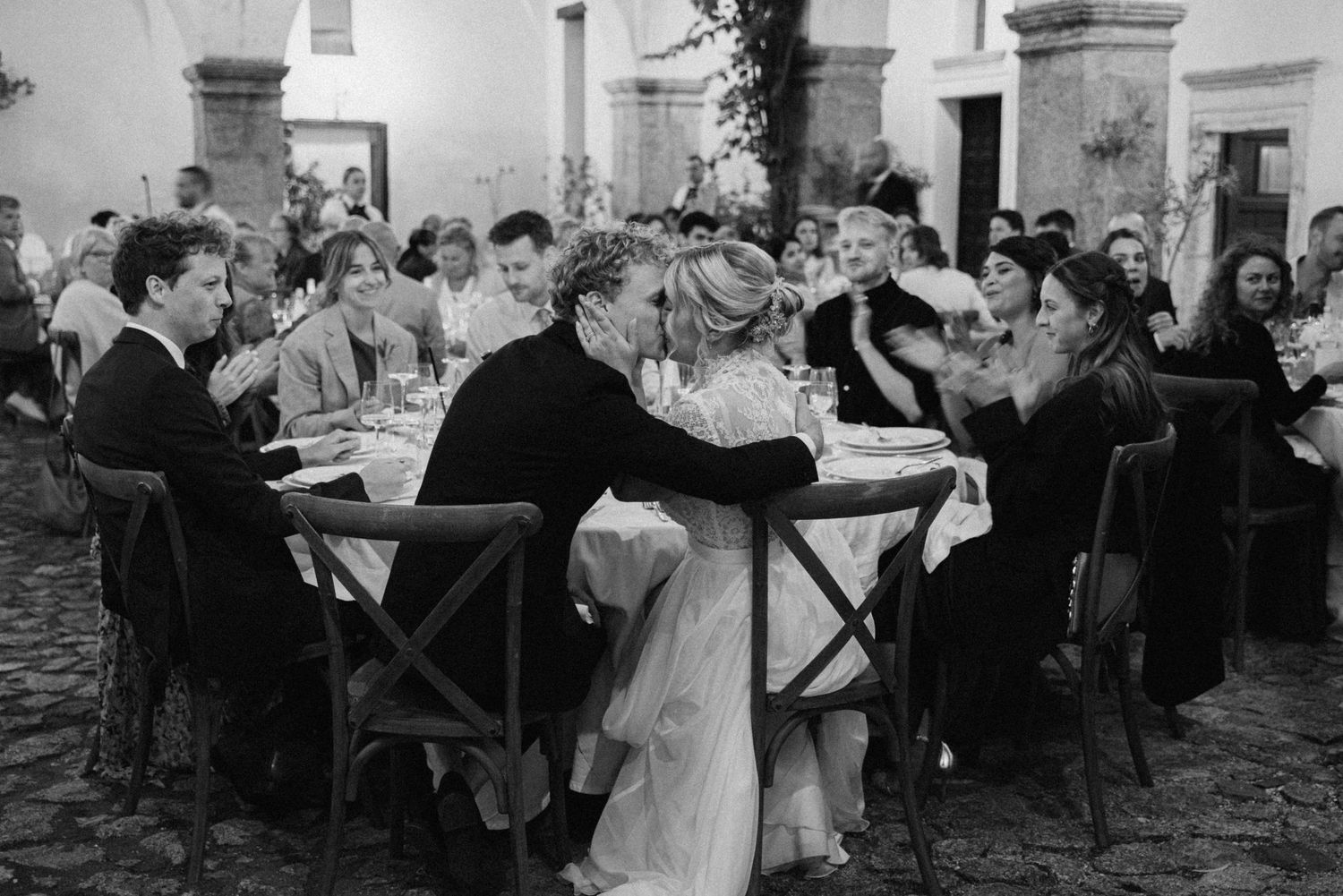 Bride and groom kissing at their table during the reception
