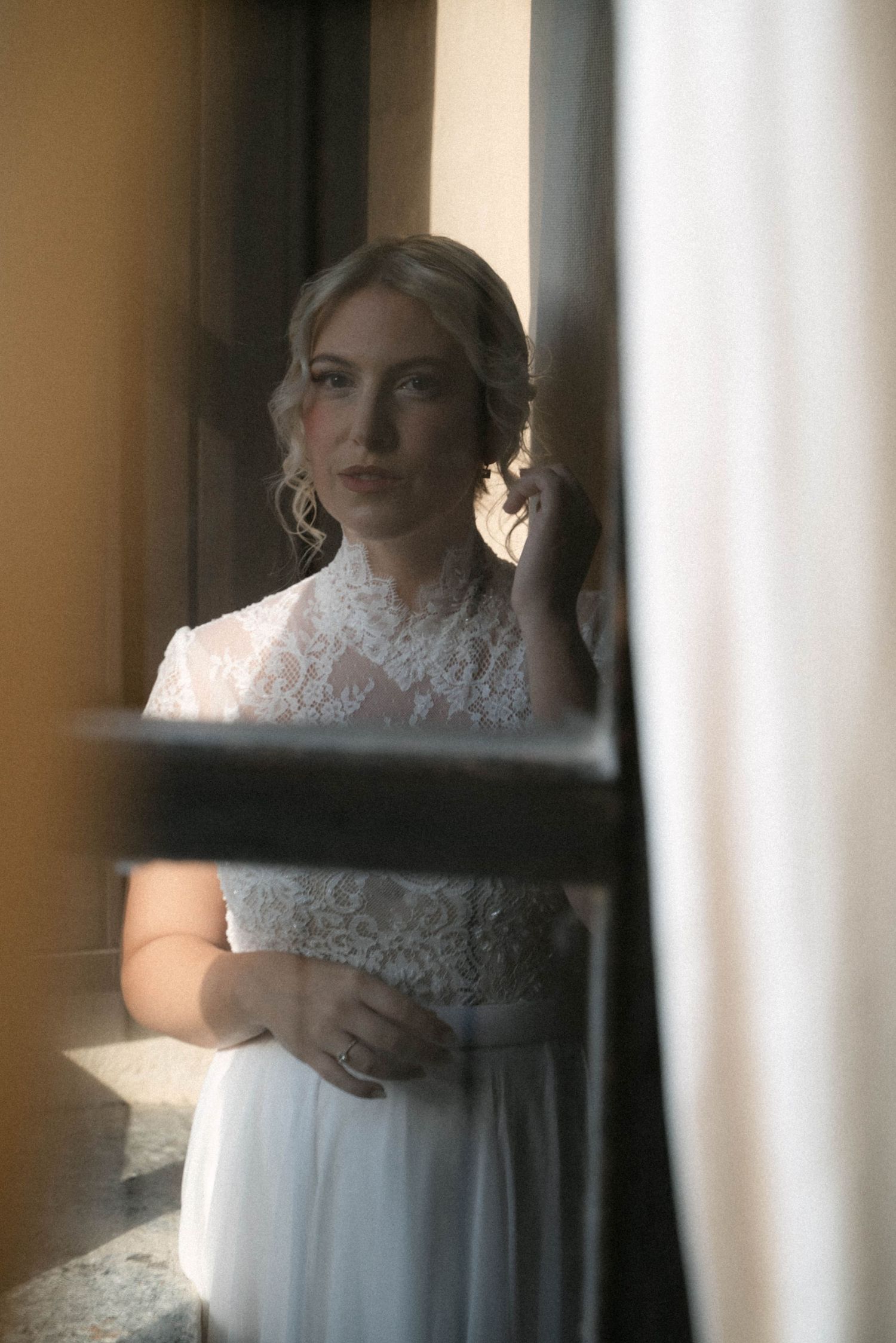 Bride reflected in a window before the wedding ceremony