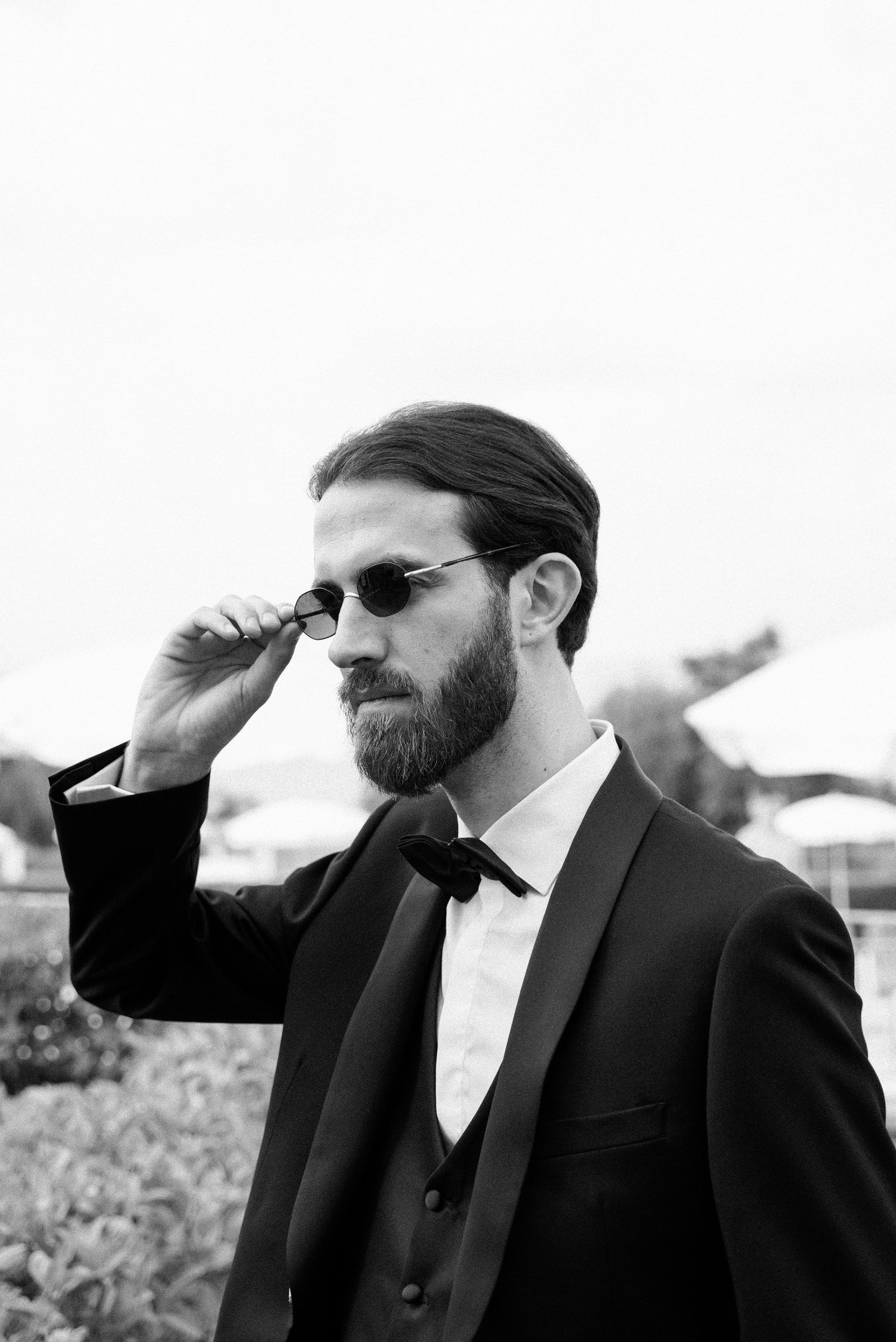 Black and white portrait of the groom wearing sunglasses