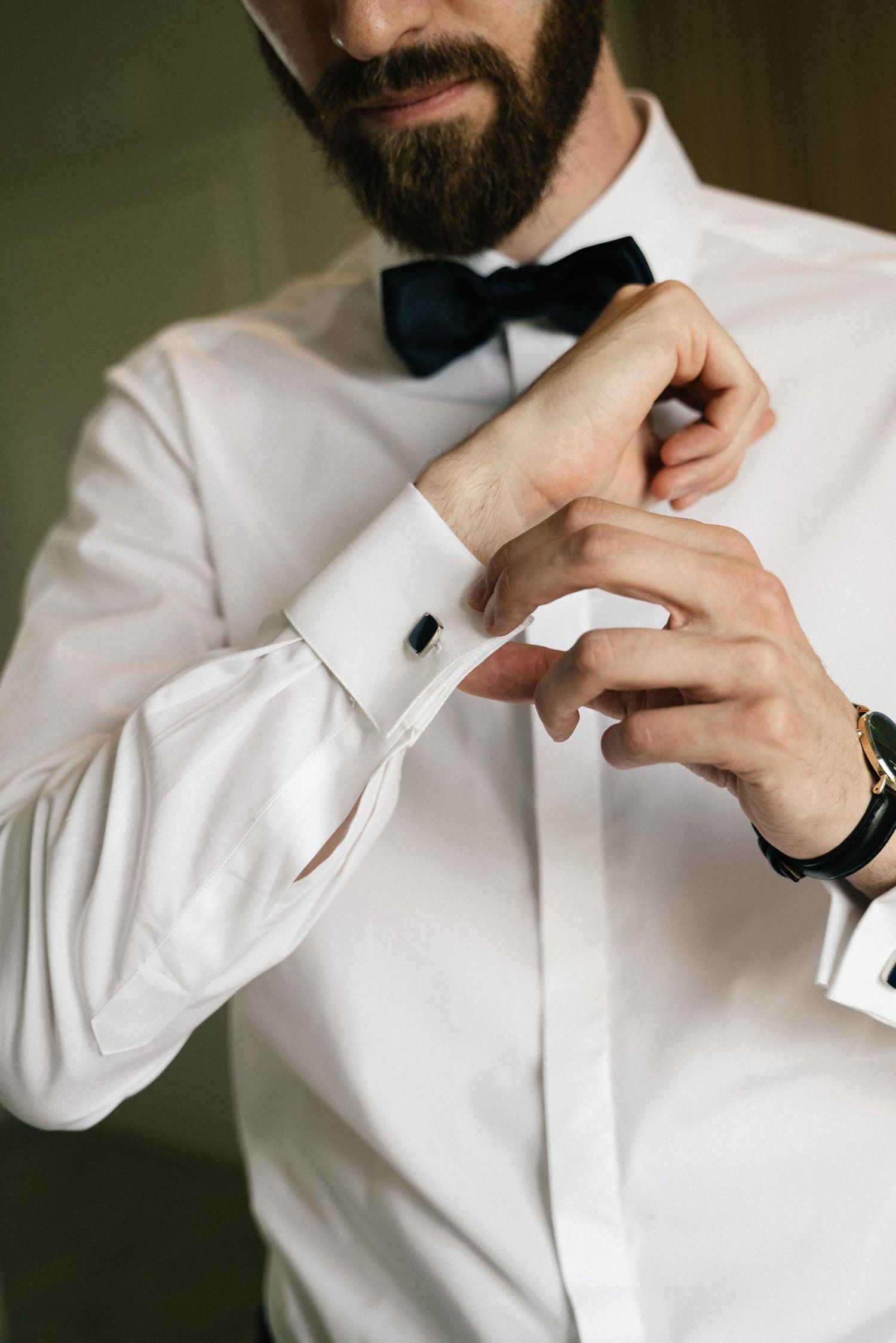 Groom fastening his cufflinks before the wedding in Tropea