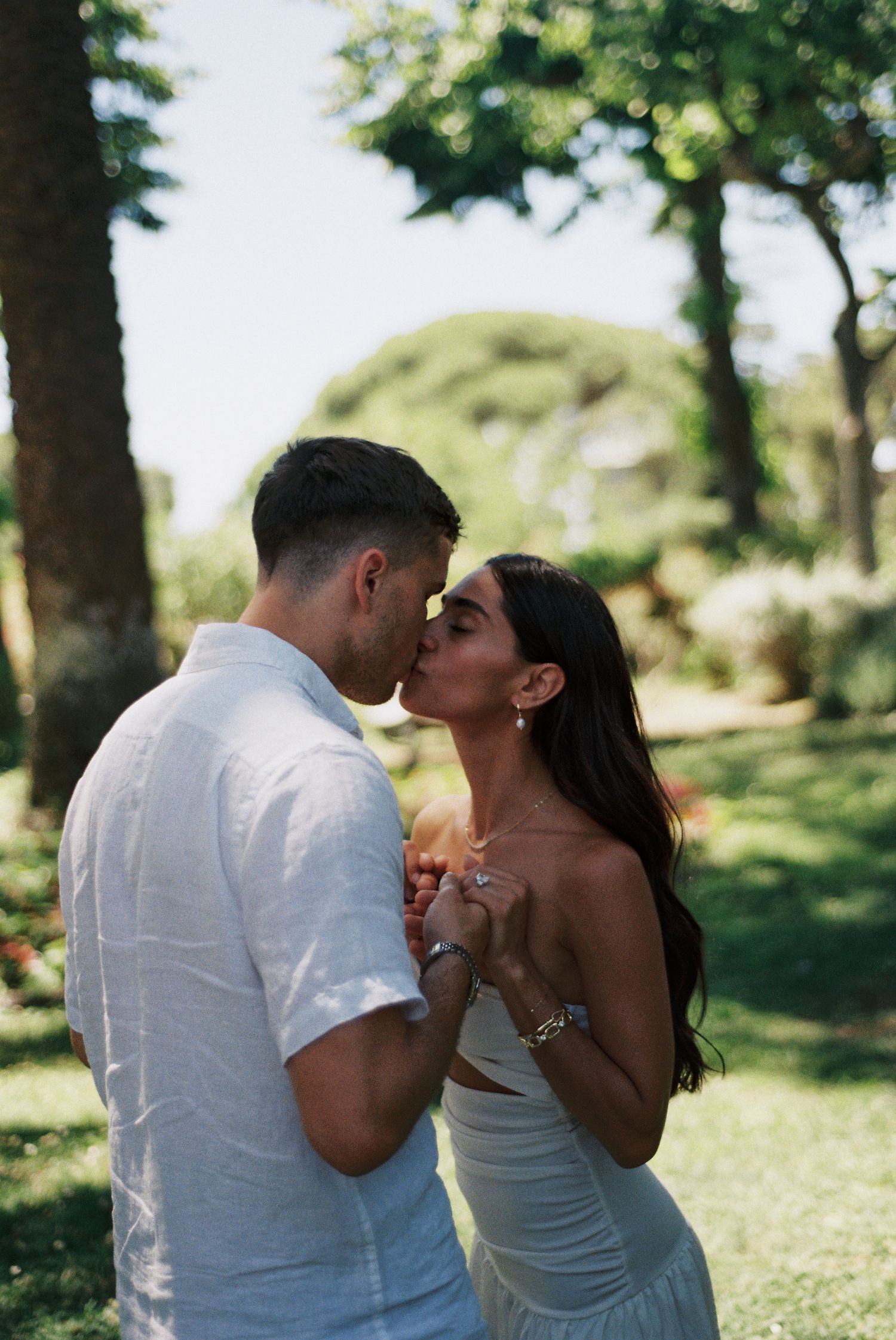 Newly engaged couple sharing a kiss in a garden in Ravello