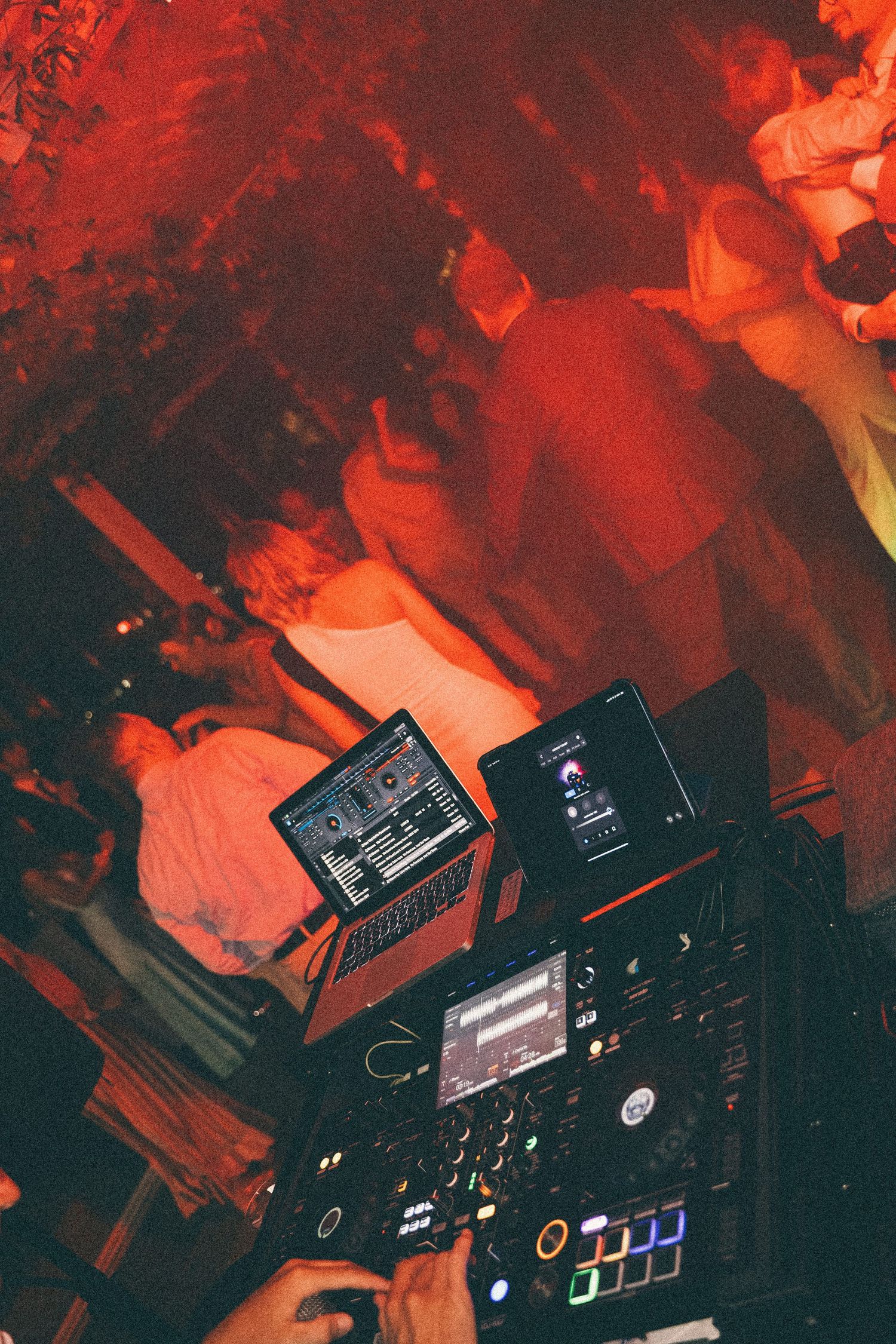 DJ booth and guests dancing during the nighttime wedding party