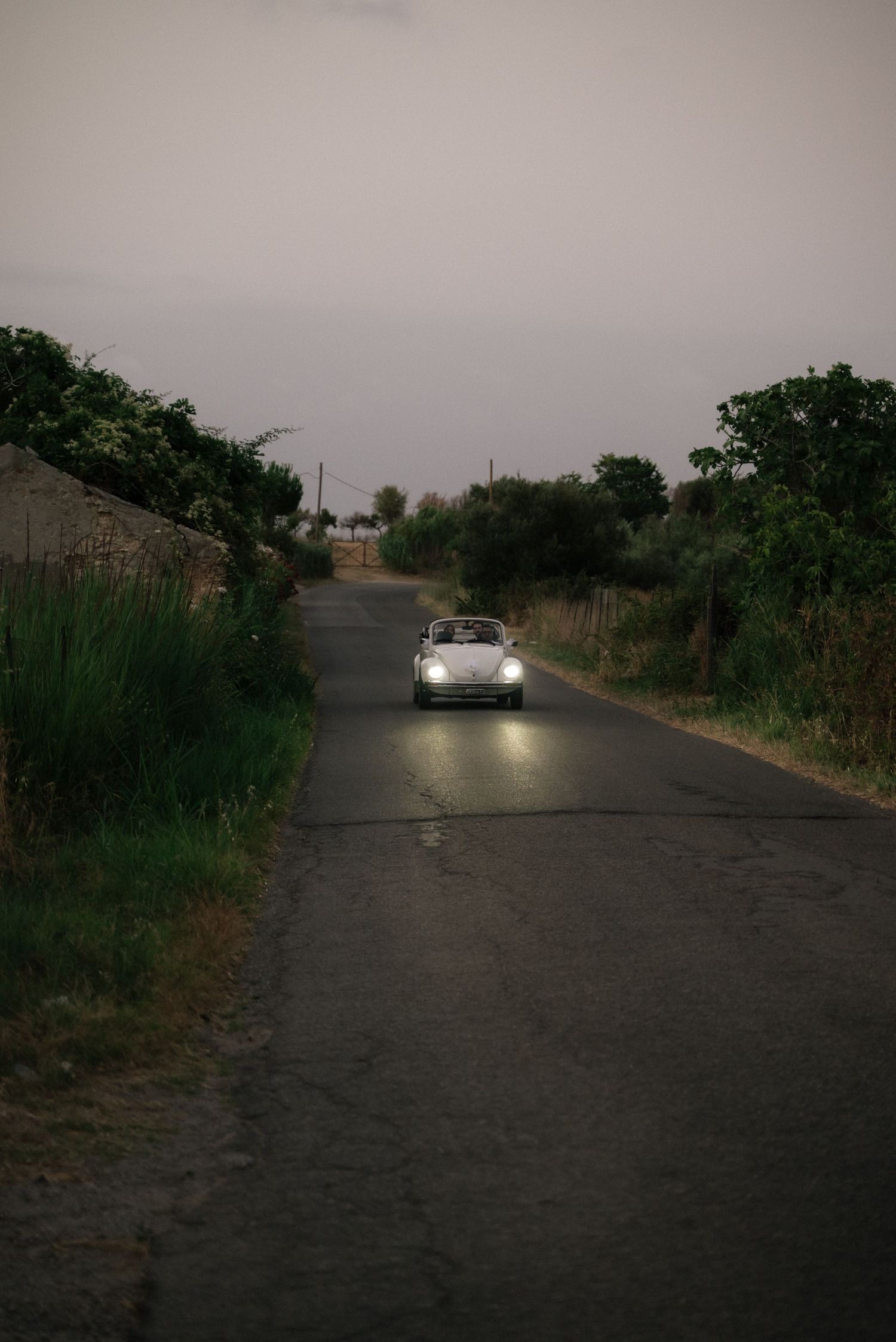 Newlyweds travelling to Villa Perara in a vintage convertible