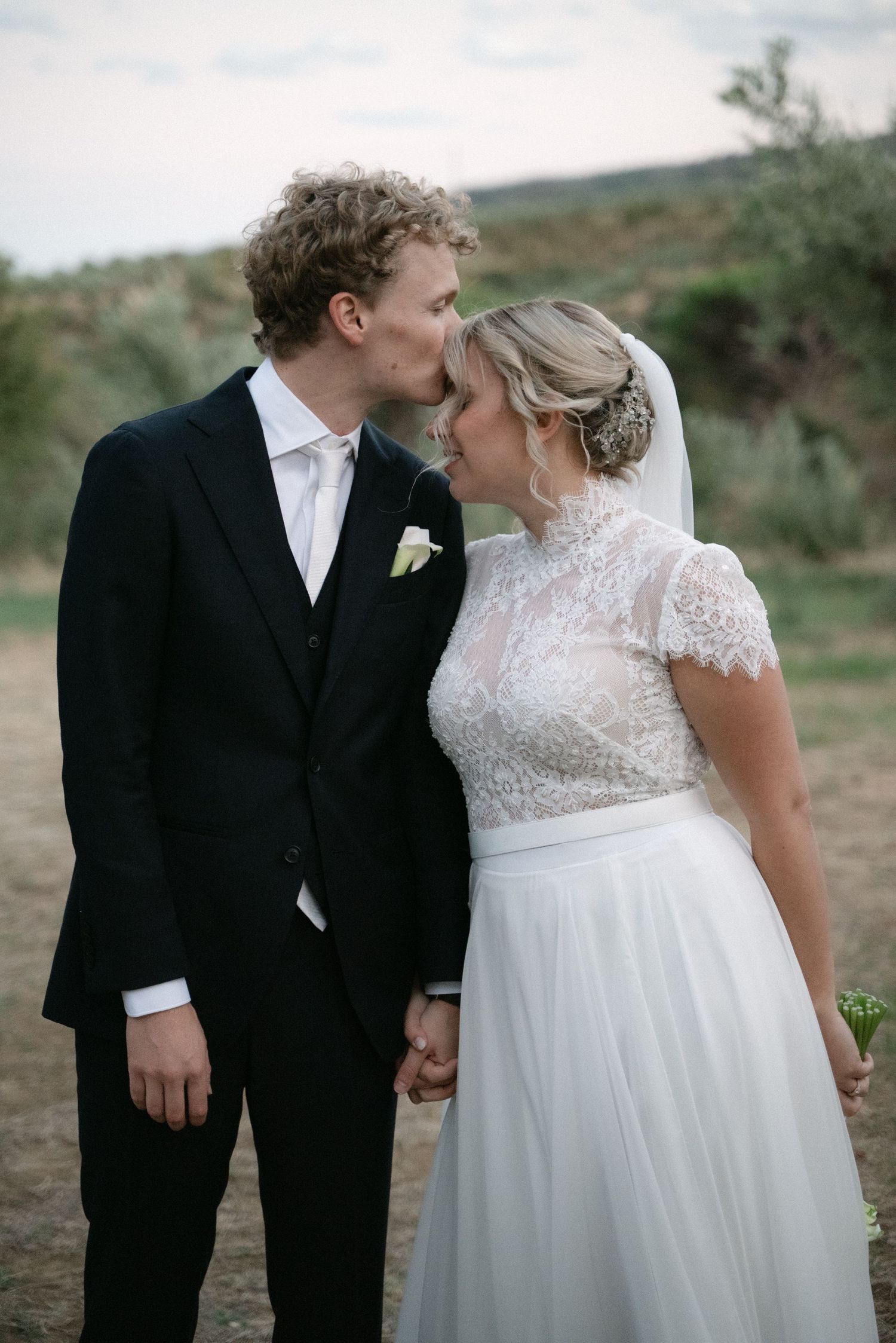 Groom kissing his bride on the forehead in Calabria
