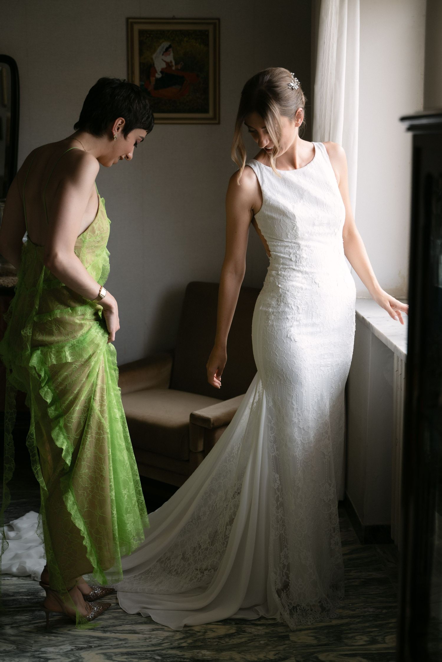 Bride wearing her wedding dress beside a window