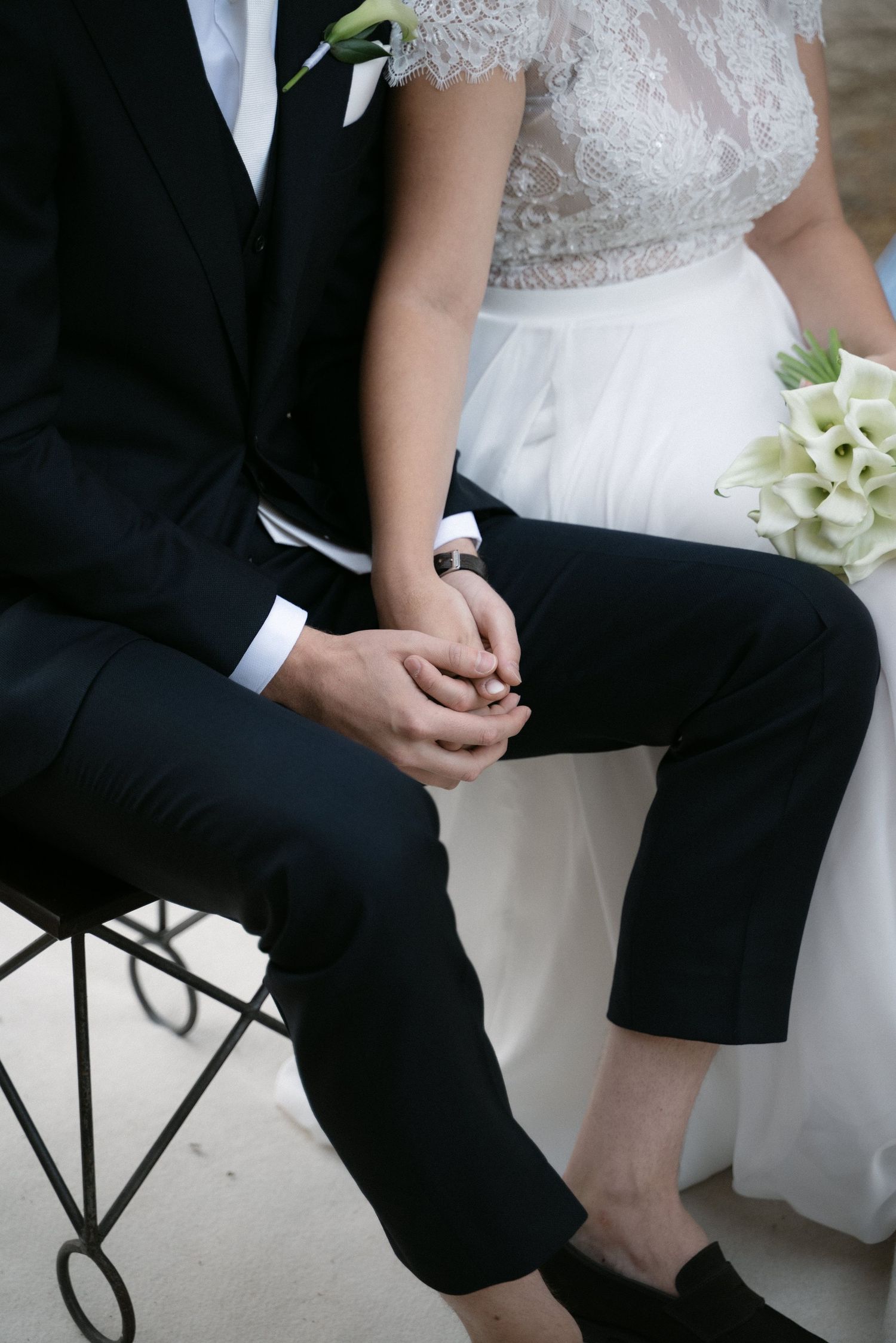 Close-up of the bride and groom holding hands