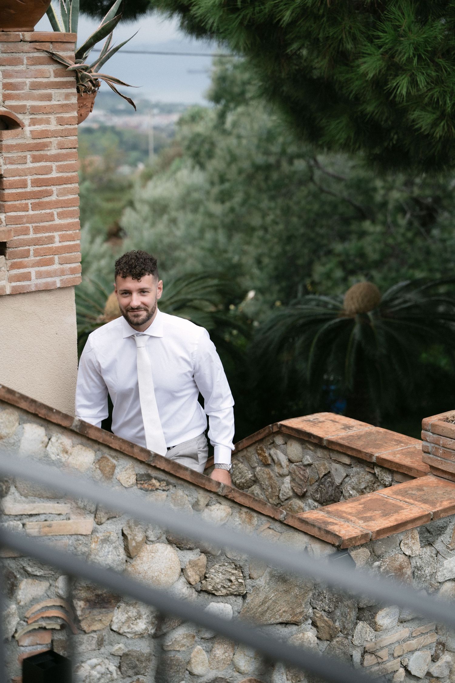 Groom walking through the stone villa during preparations