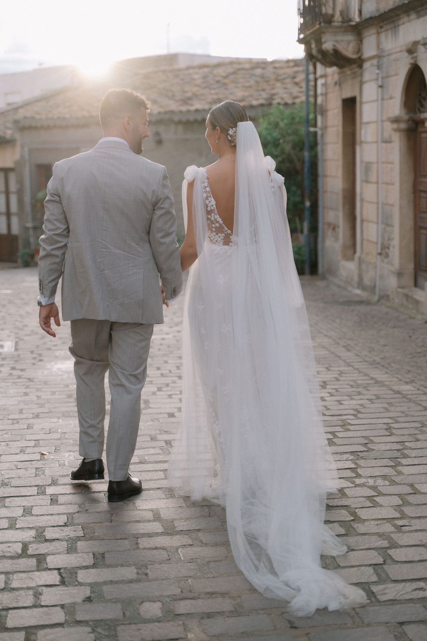 Newlyweds walking through historic architecture during their Sicily wedding