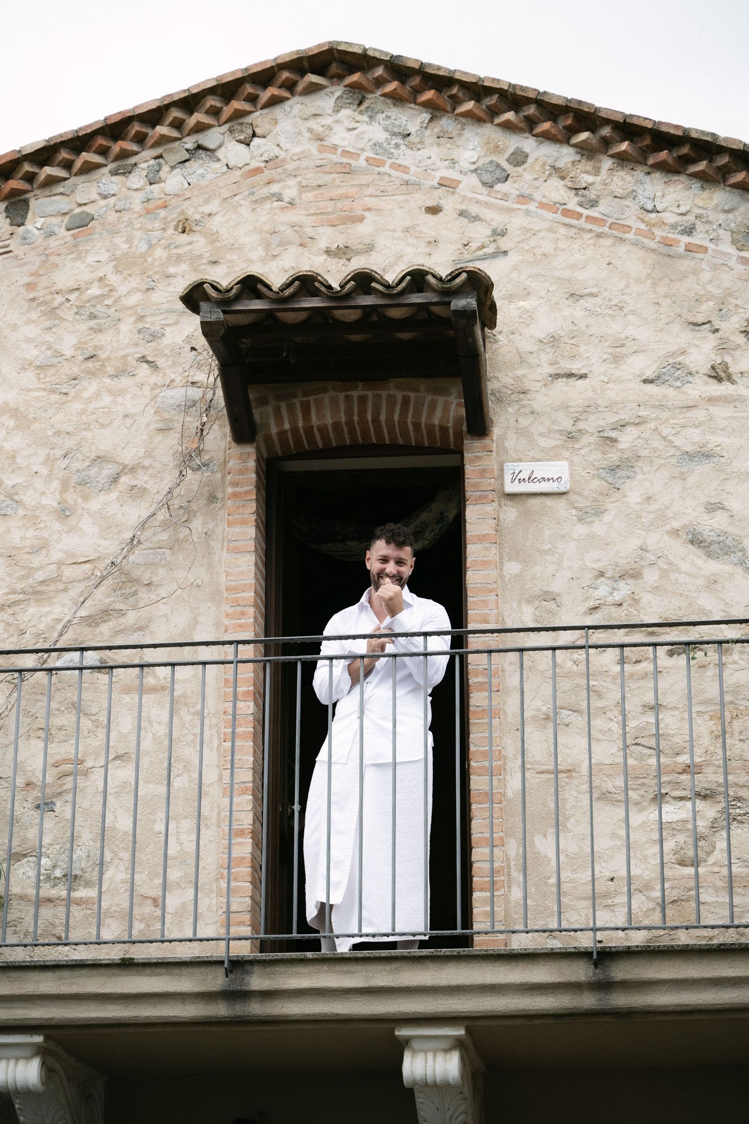 Groom getting ready on the balcony before his wedding in Sicily