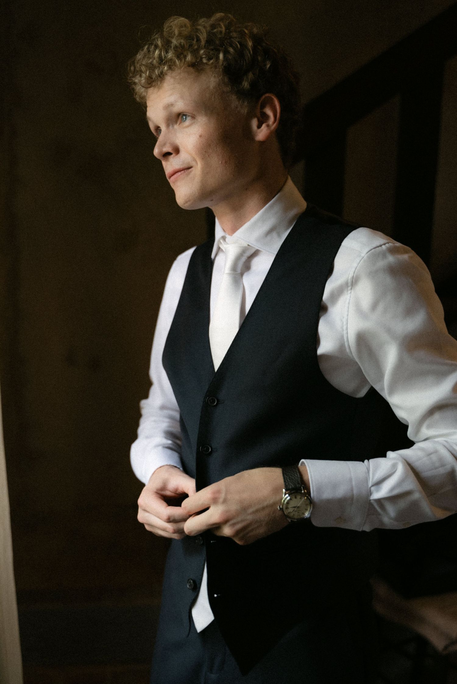 Groom wearing a black waistcoat before his wedding in Calabria