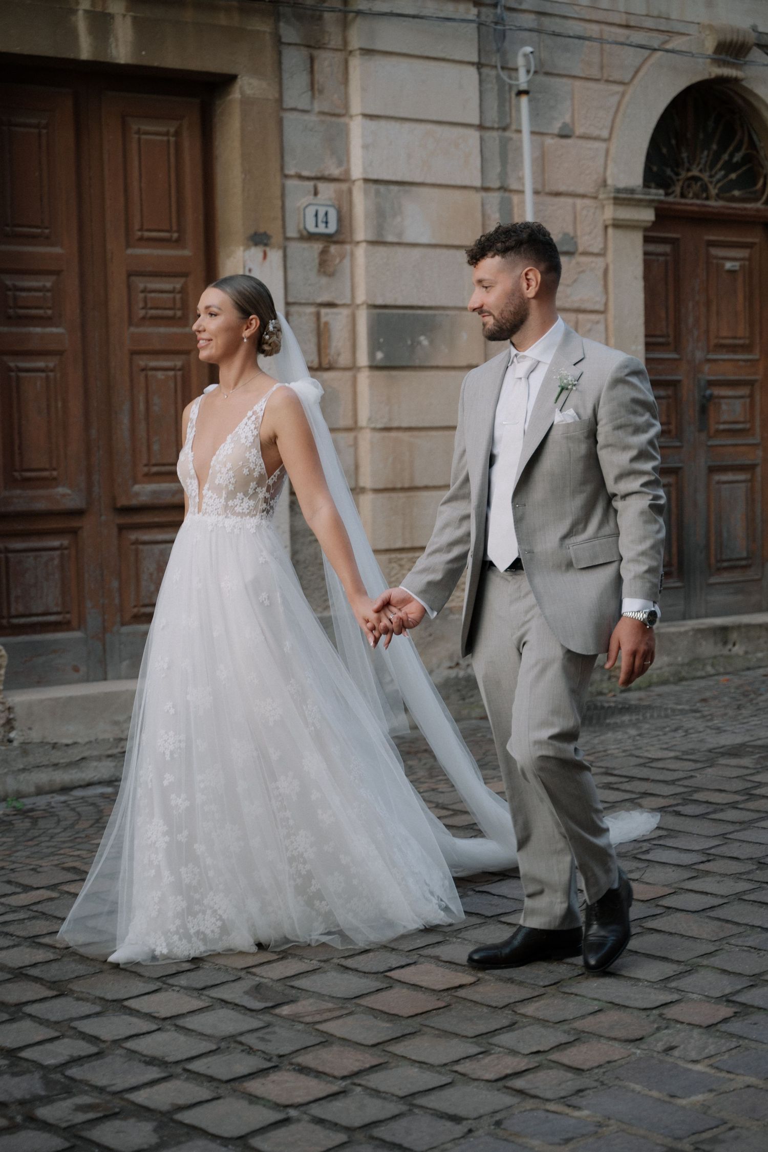 Newlyweds walking through a historic Sicilian village
