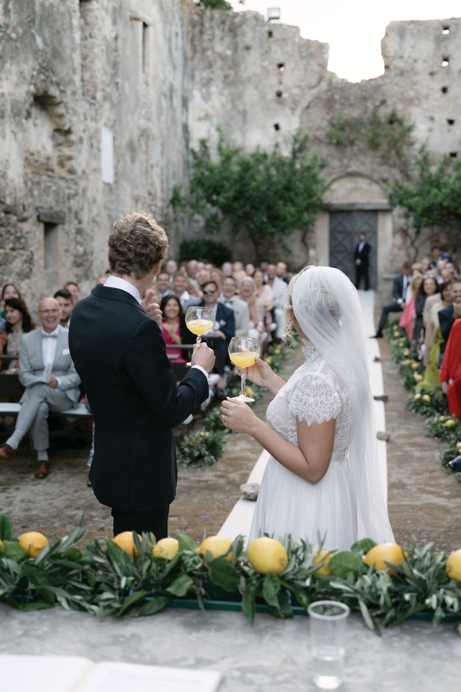 Bride and groom toasting with guests during the wedding ceremony