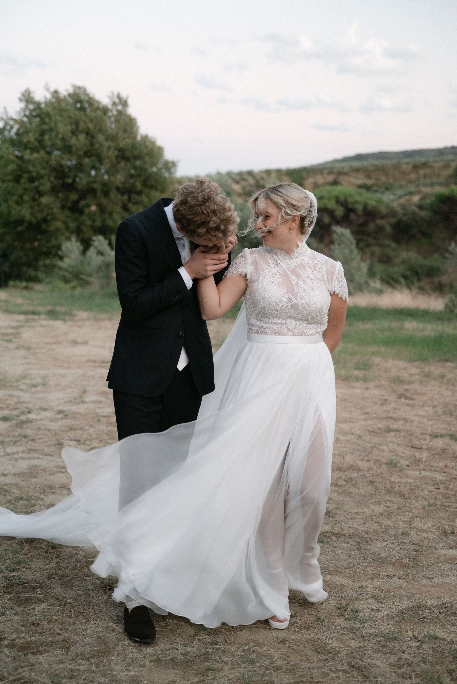 Groom kissing the bride's hand during their wedding portraits