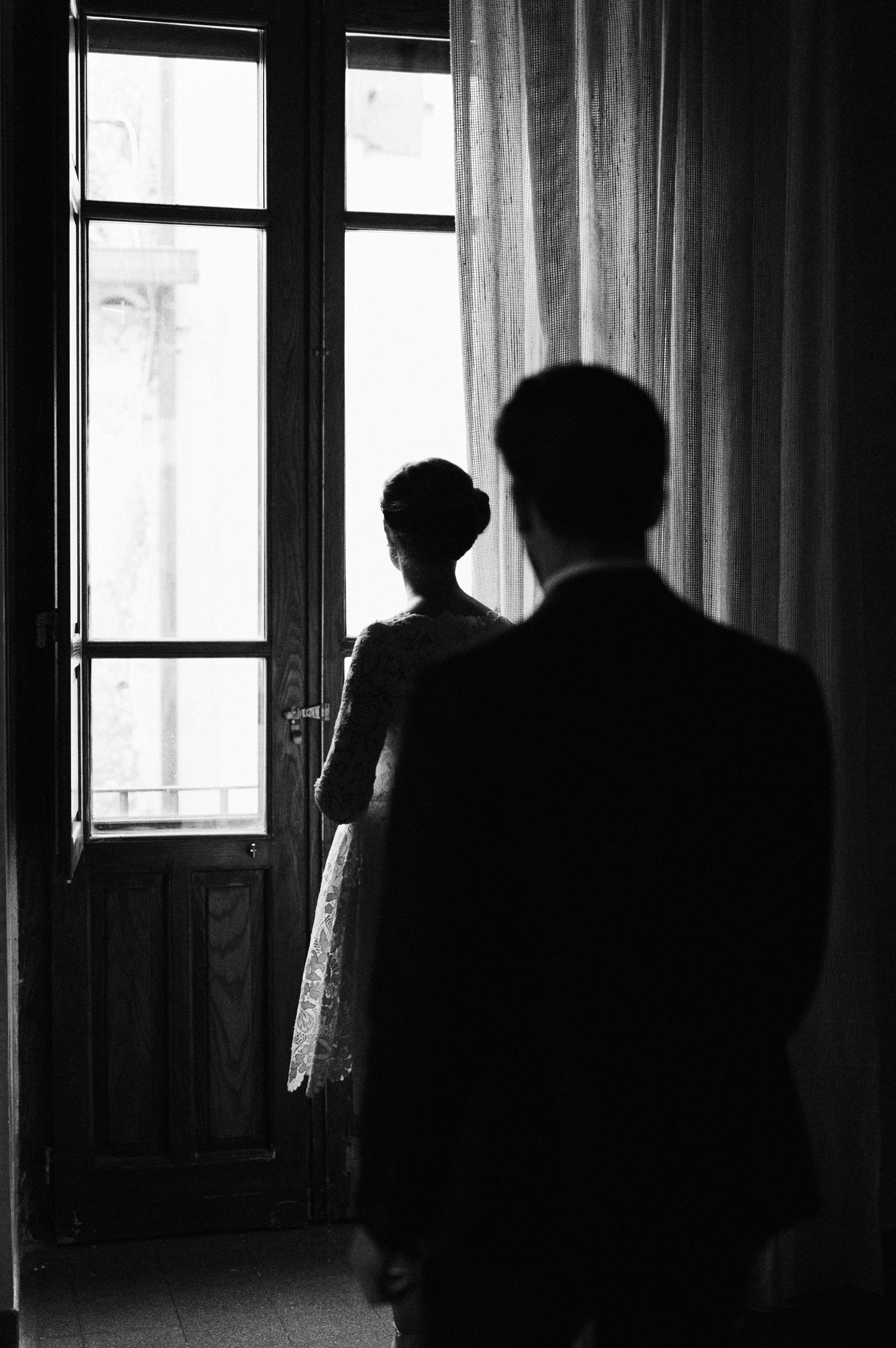 Bride and groom by a window during their wedding in Gerace