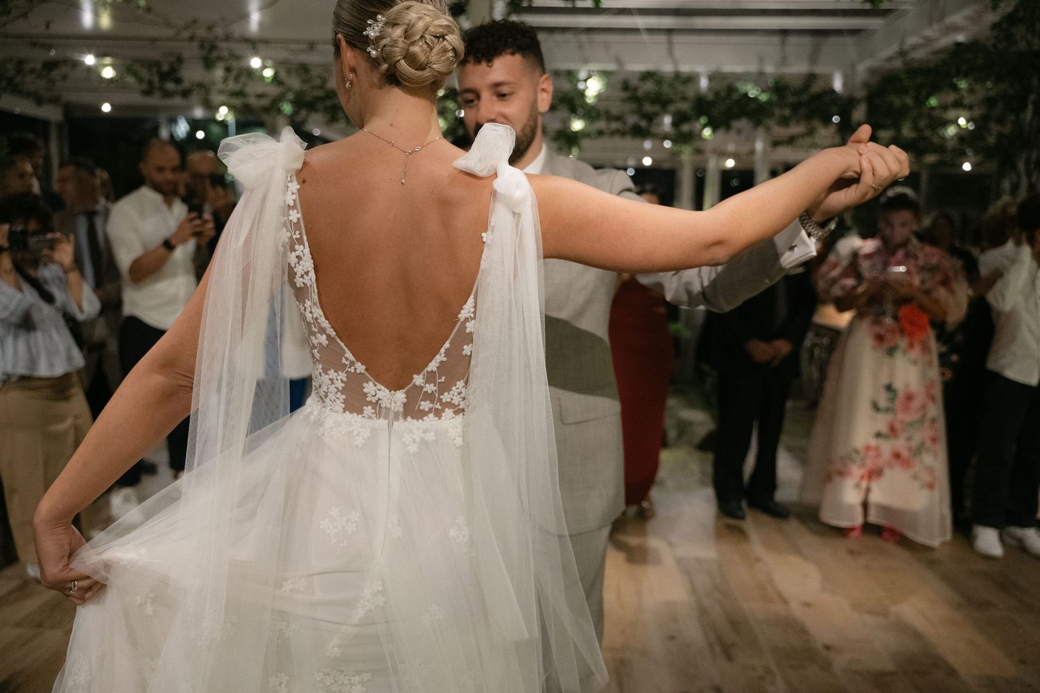 Bride and groom dancing surrounded by wedding guests