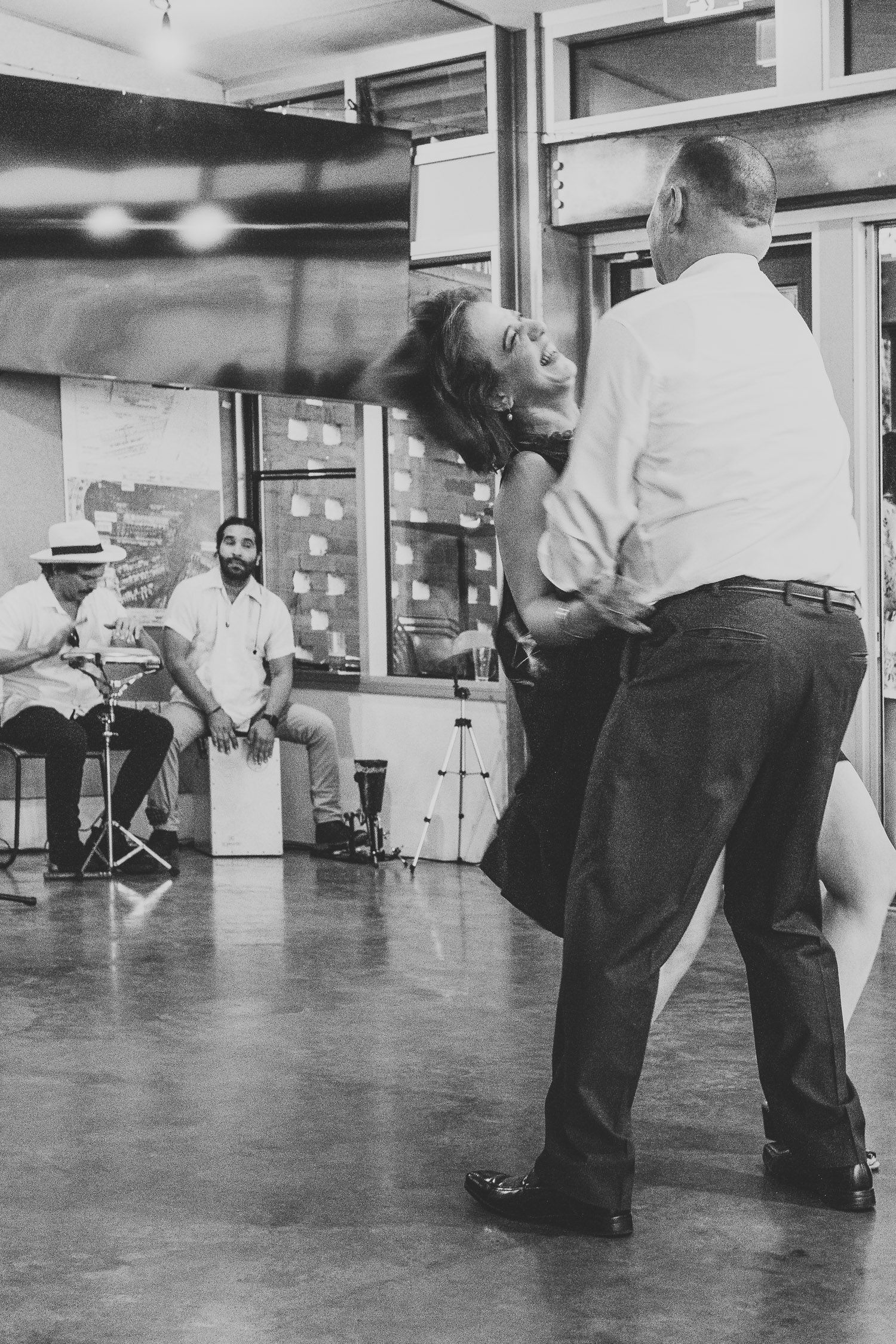 Couple dancing tango in black and white at a wedding reception while guests watch.