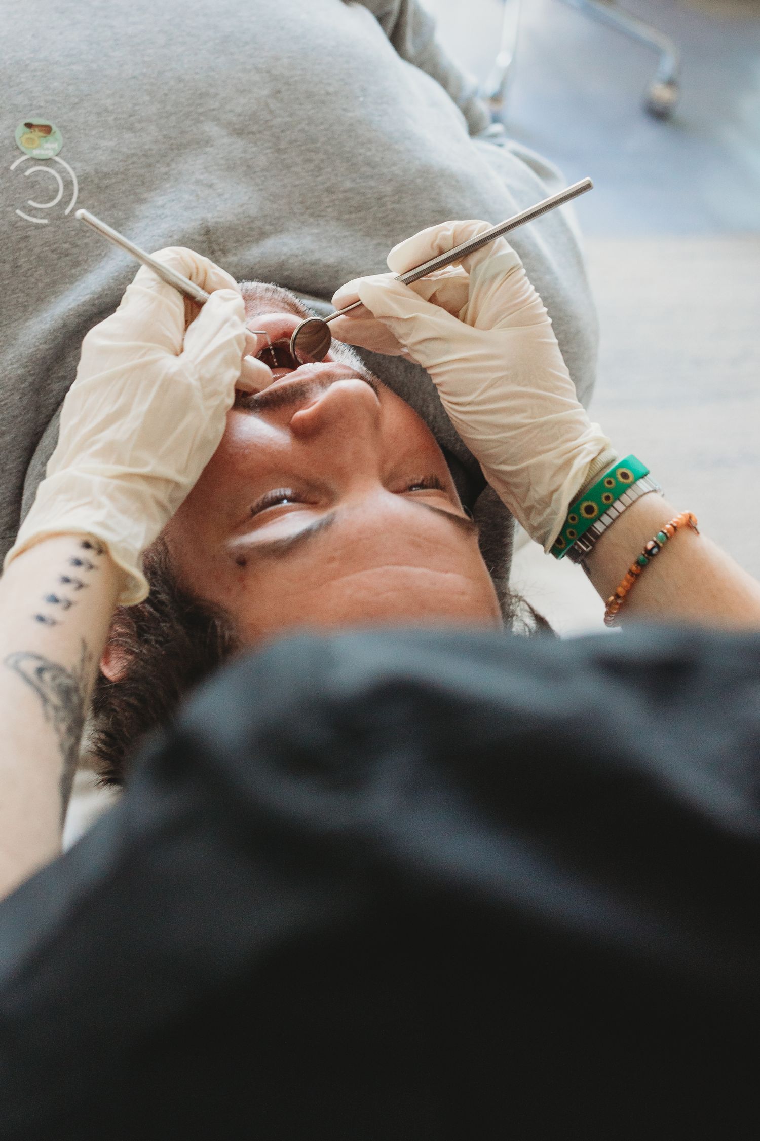 Dentist in gloves examining patient's teeth with dental tools during oral checkup.