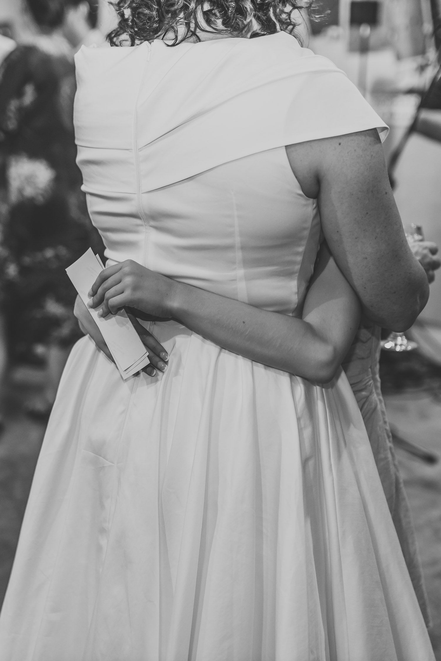 Black and white close-up of bride in elegant off-shoulder white wedding dress.