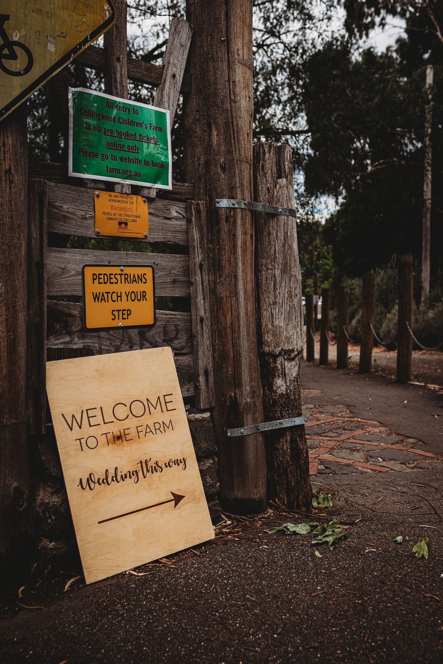Rustic wooden welcome sign at a farm wedding venue directing guests with an arrow.
