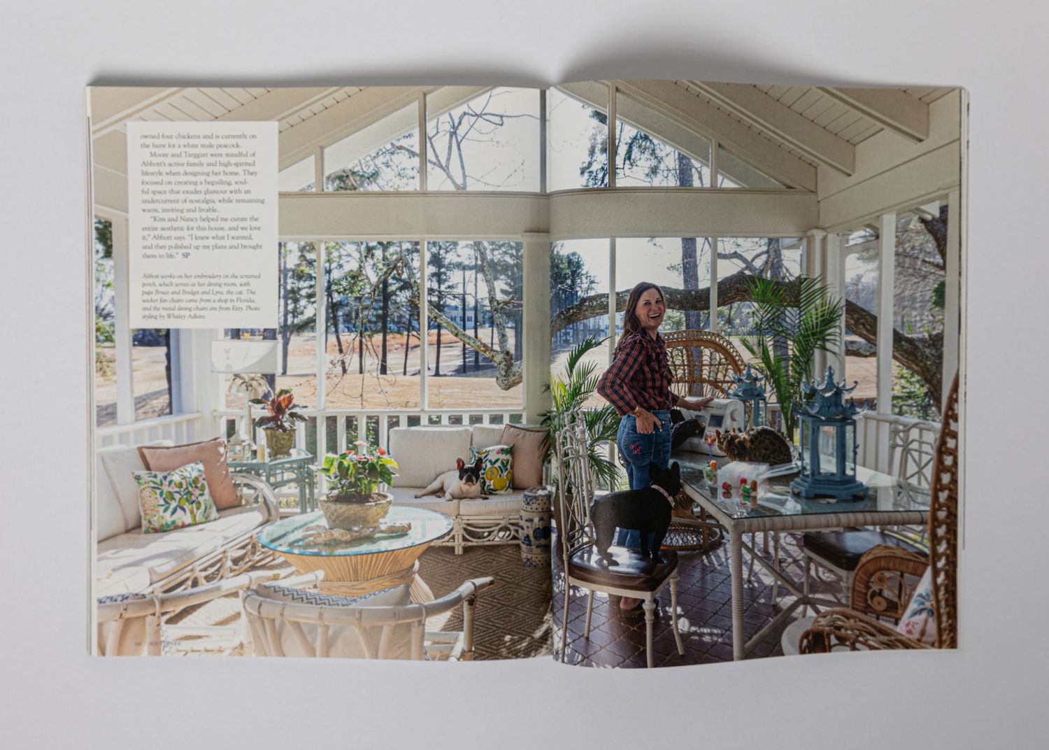 Bright sunroom interior with wicker furniture, potted plants, and large windows showcasing a cozy reading nook.