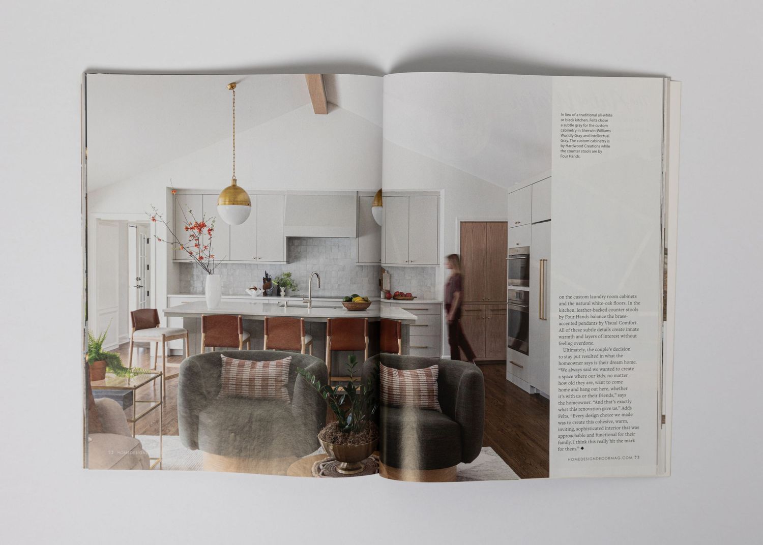 Modern kitchen interior with island, pendant lighting and rustic accents shown in magazine spread.