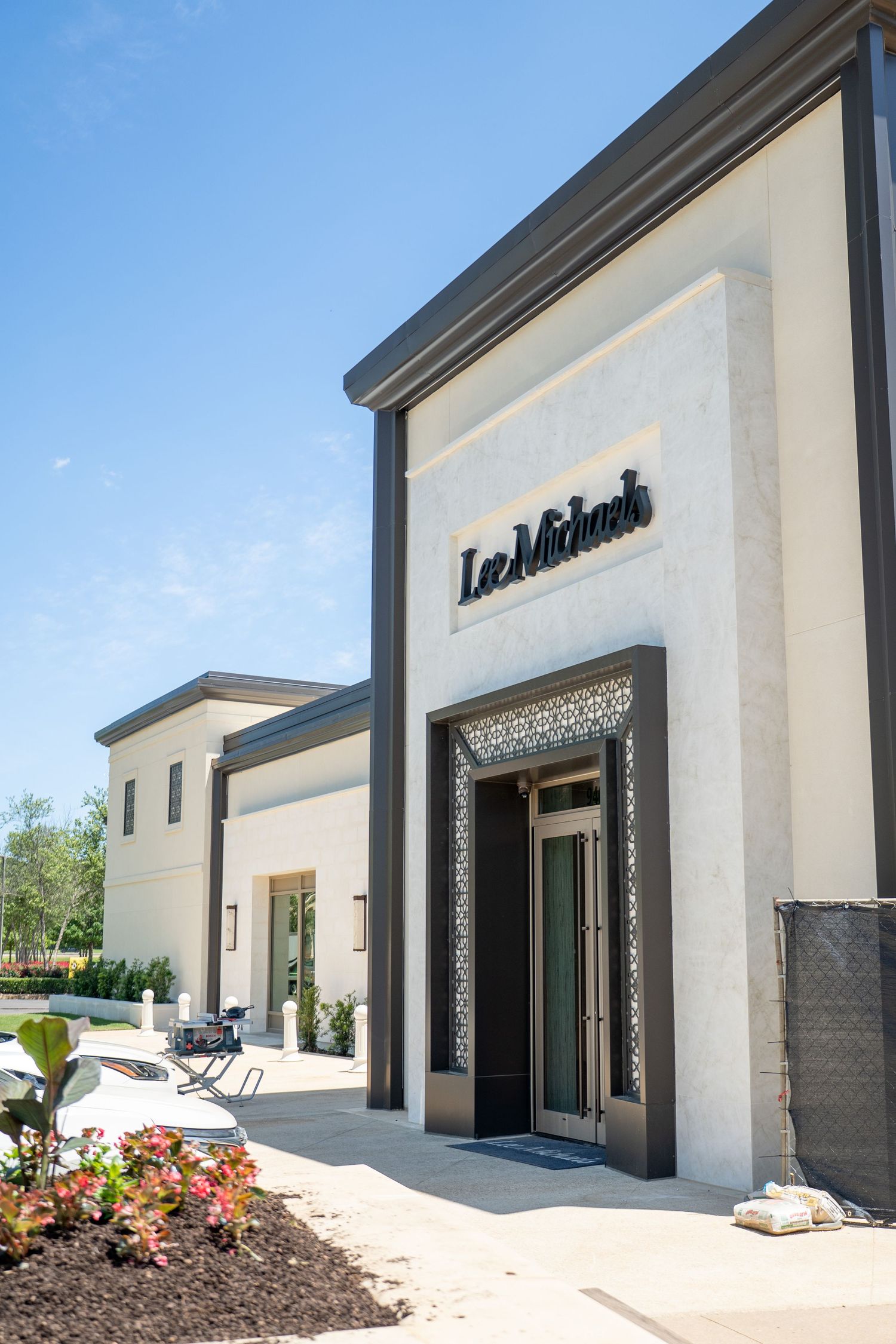 Lee Michaels fine jewelry store exterior with elegant white facade, dark trim, and decorative entrance on a sunny day.