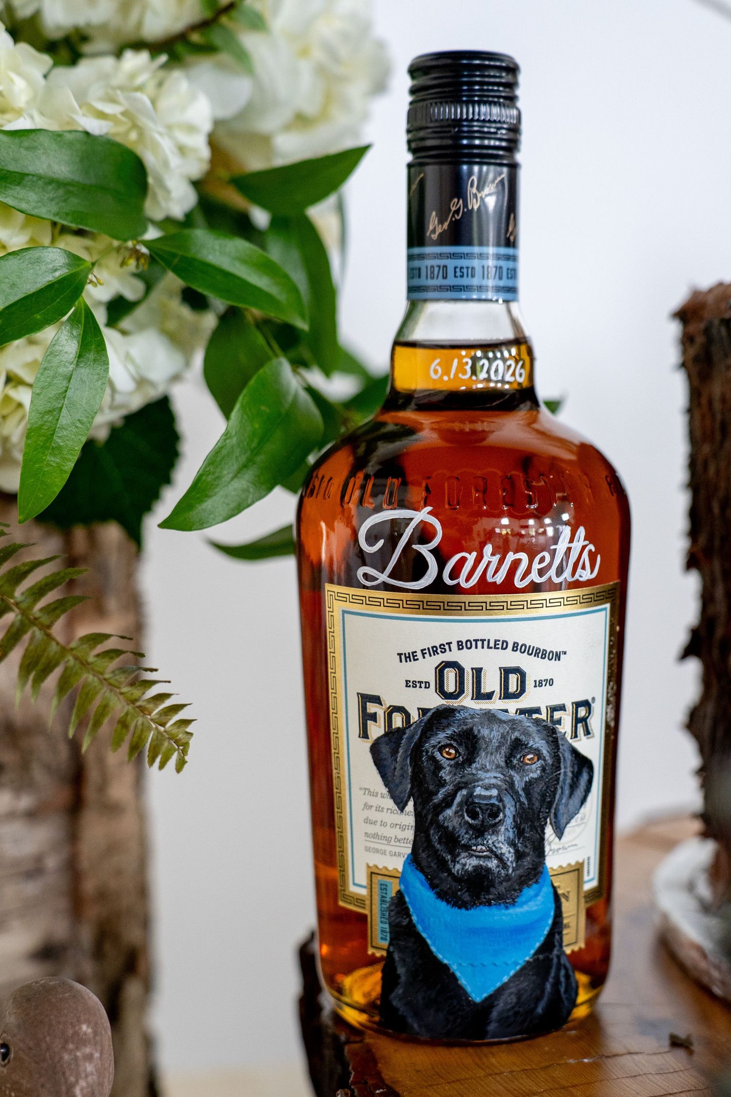 Custom Old Forester bourbon bottle labeled Barnetts with a black Labrador wearing a blue bandana, dated 6.13.2024.
