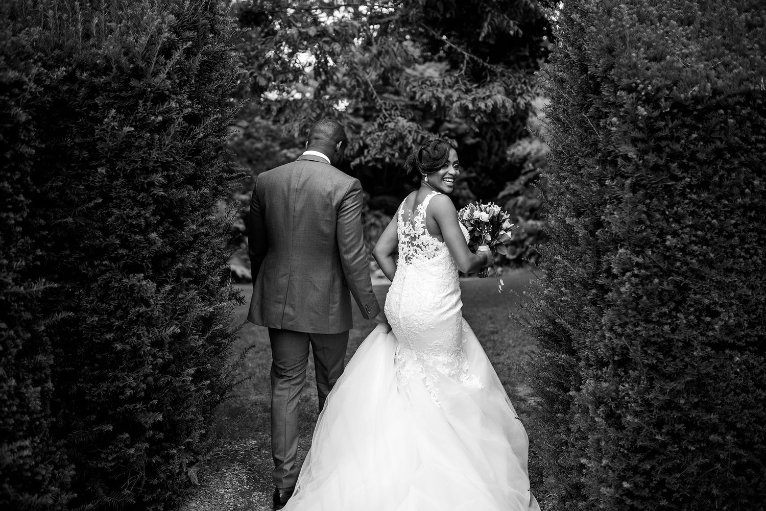 Romantic wedding couple portraits captured in a lush garden setting with natural greenery.